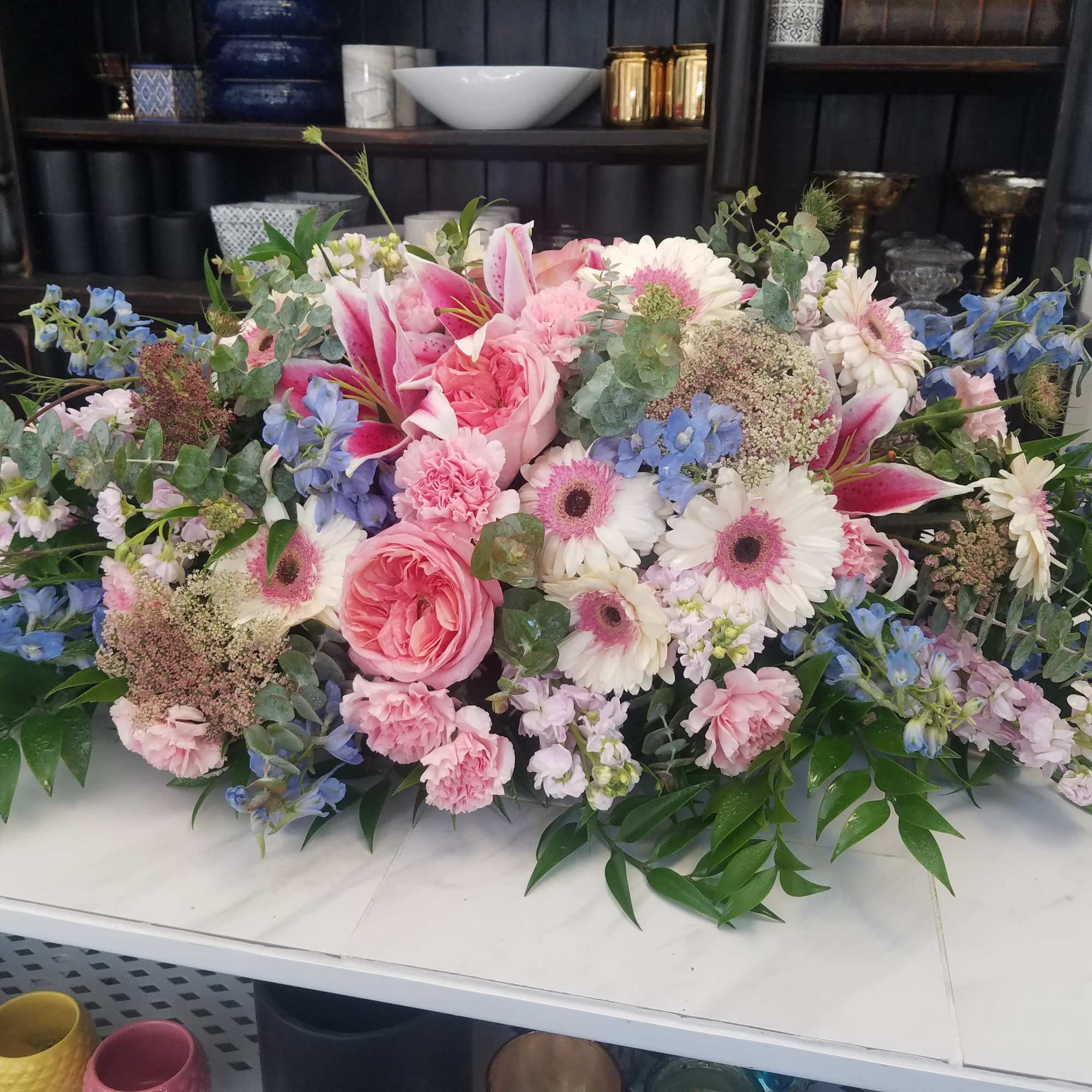 Low floral centerpiece with pink and white blooms and blue accents