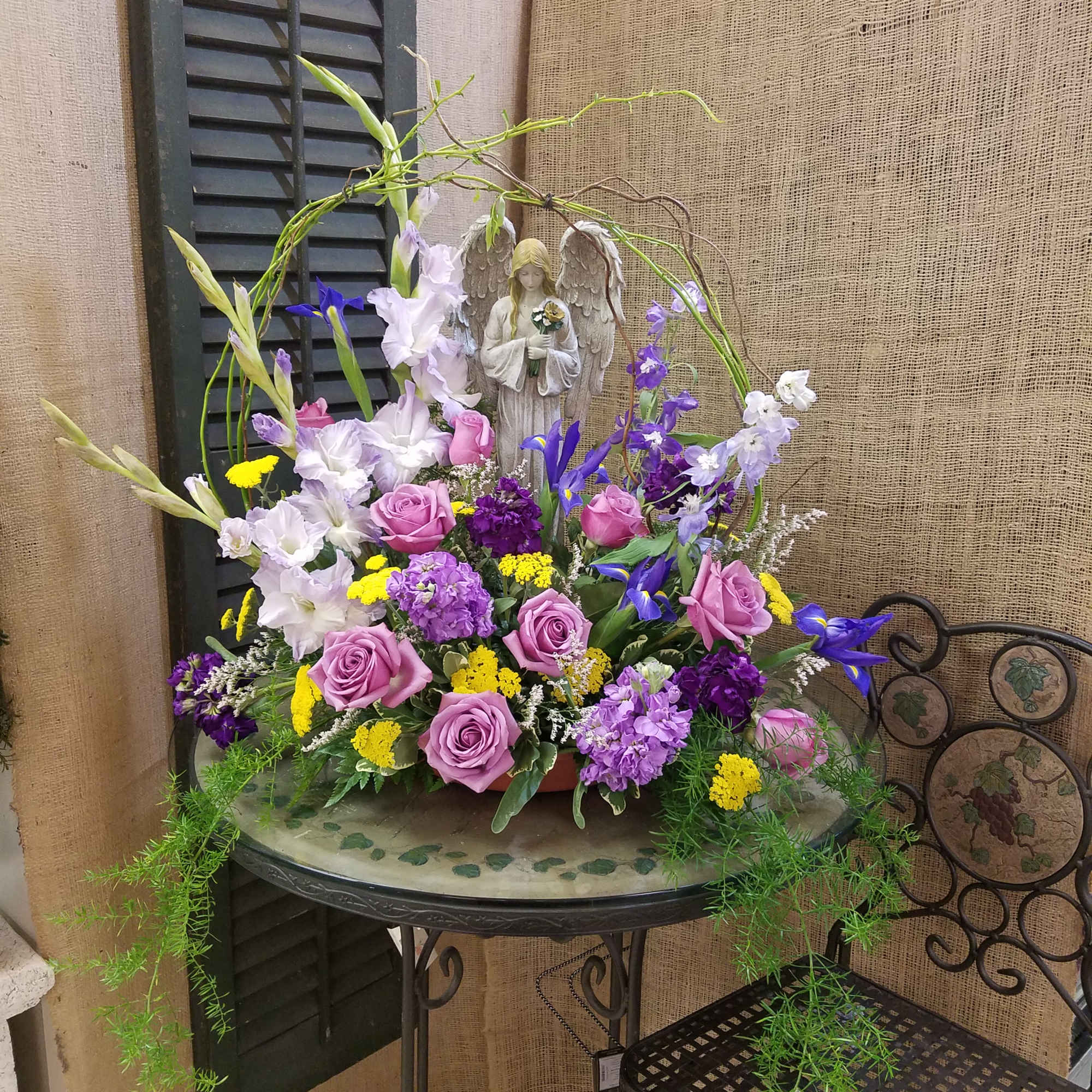 Mixed floral arrangement with a small angel figurine in the center