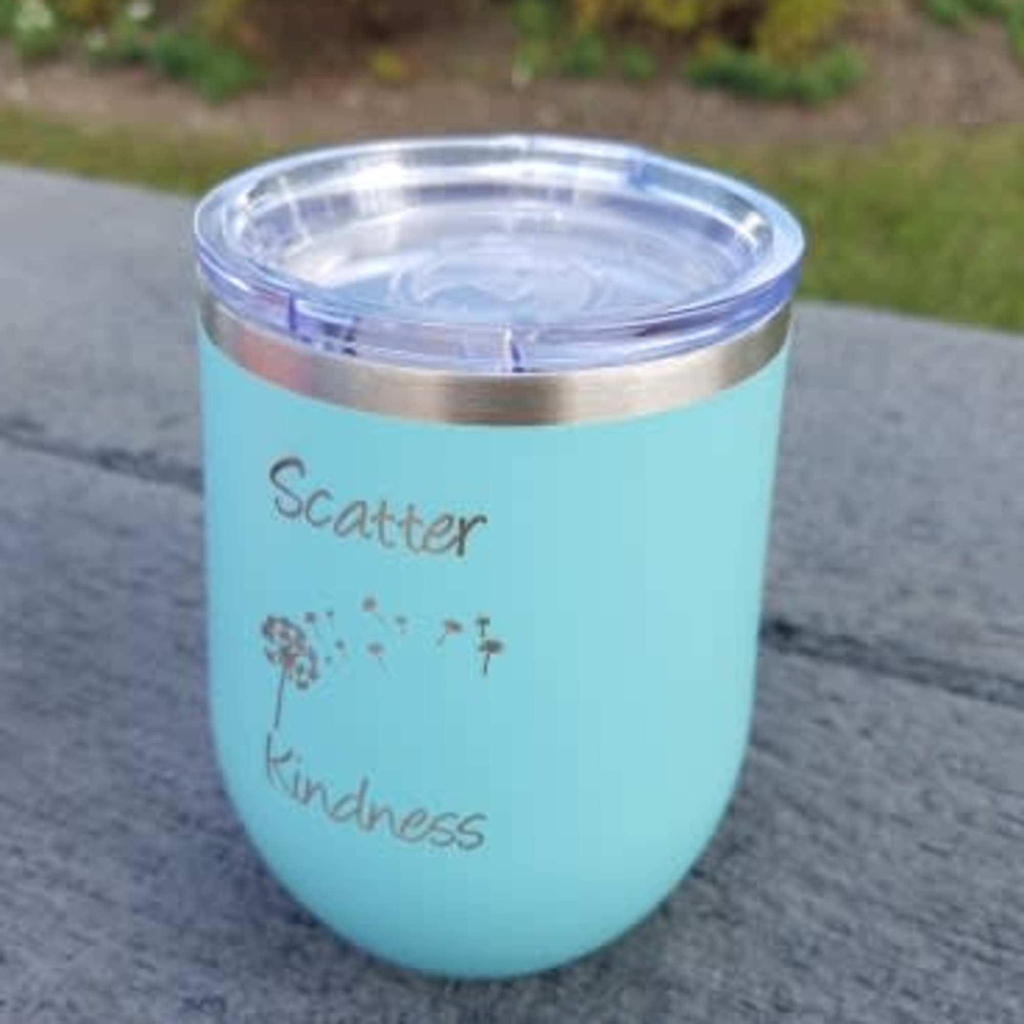 A turquoise insulated tumbler with the words "Scatter Kindness"