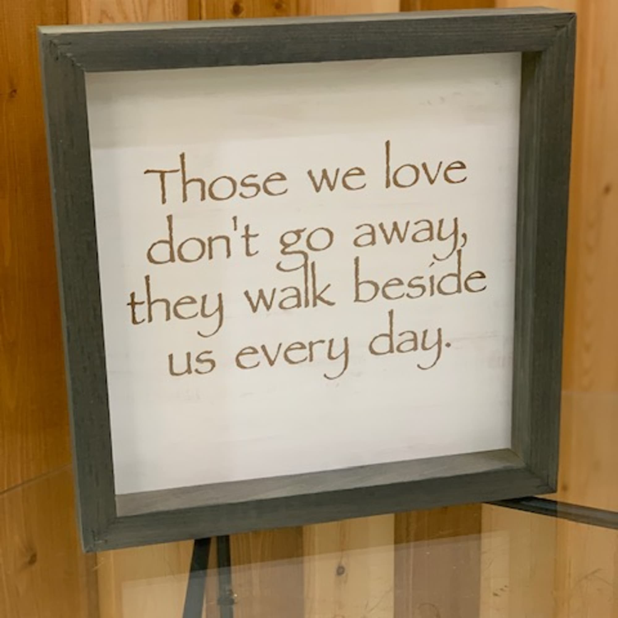 Framed sign with a memorial quote on a stand