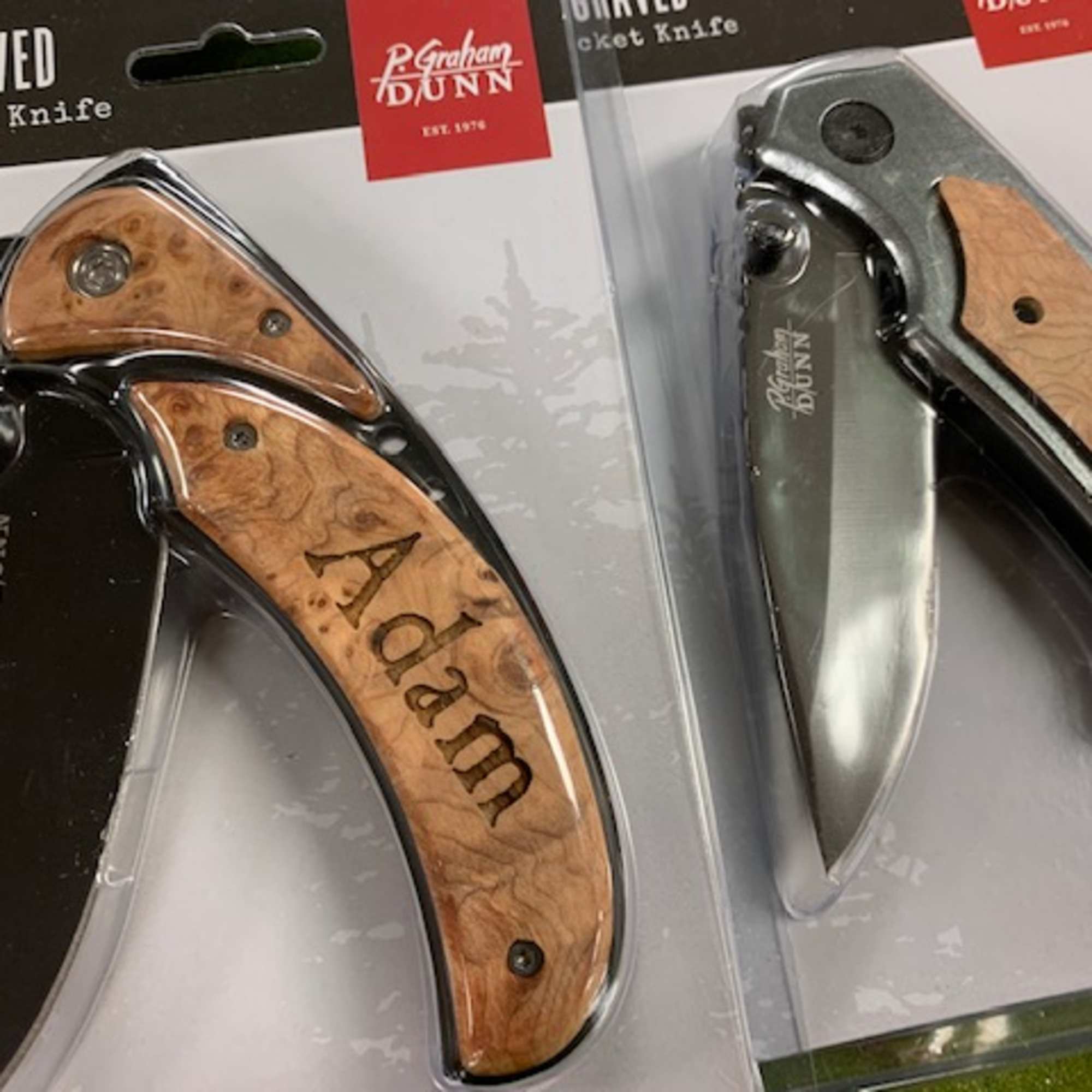 Two engraved pocket knives in retail packaging