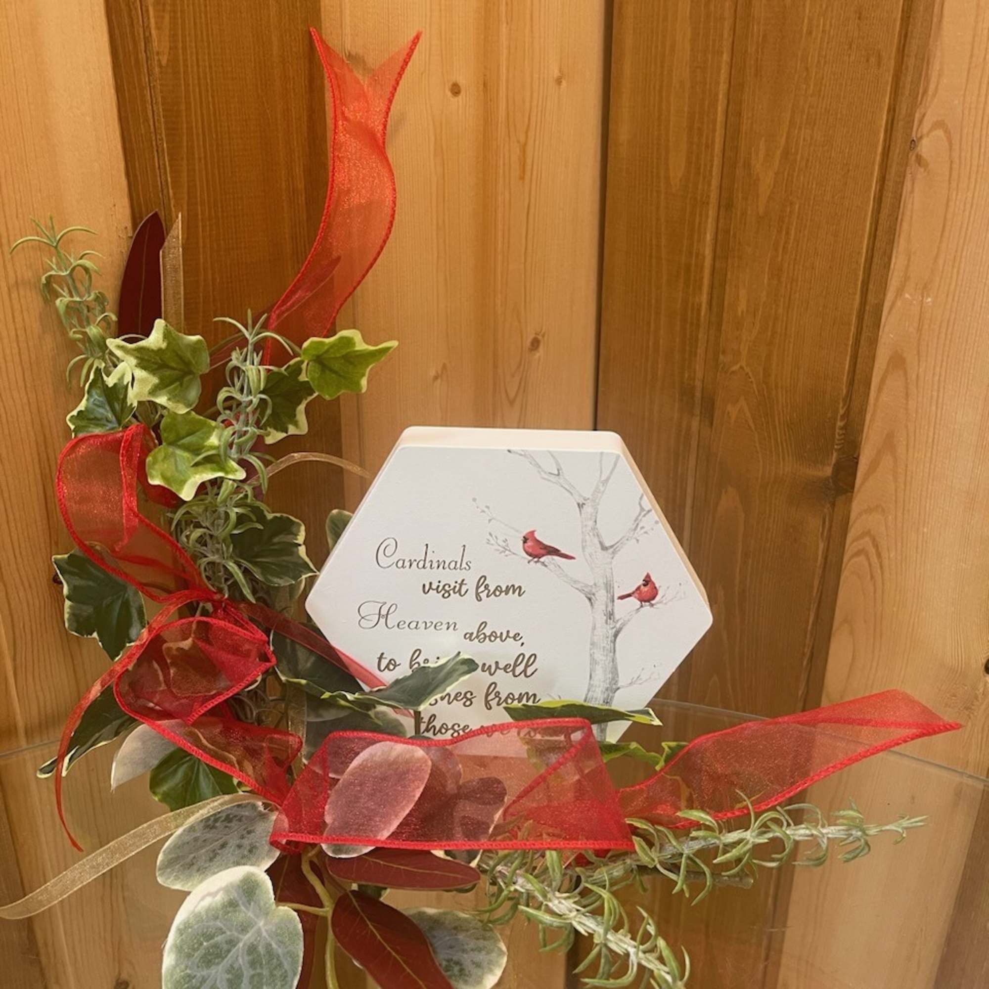 Decorative sympathy plaque with faux greenery and red ribbon