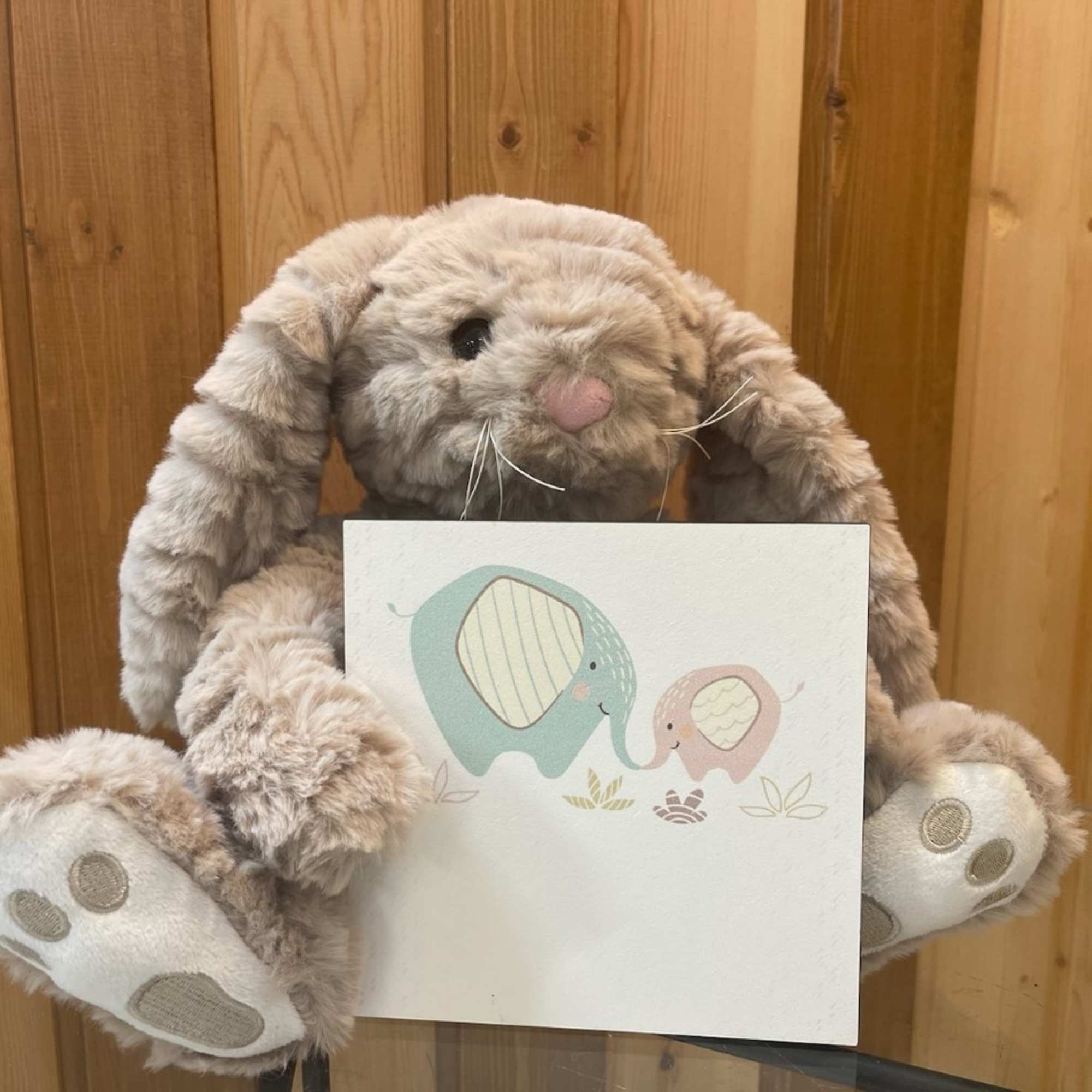Plush bunny holding a card with two elephants