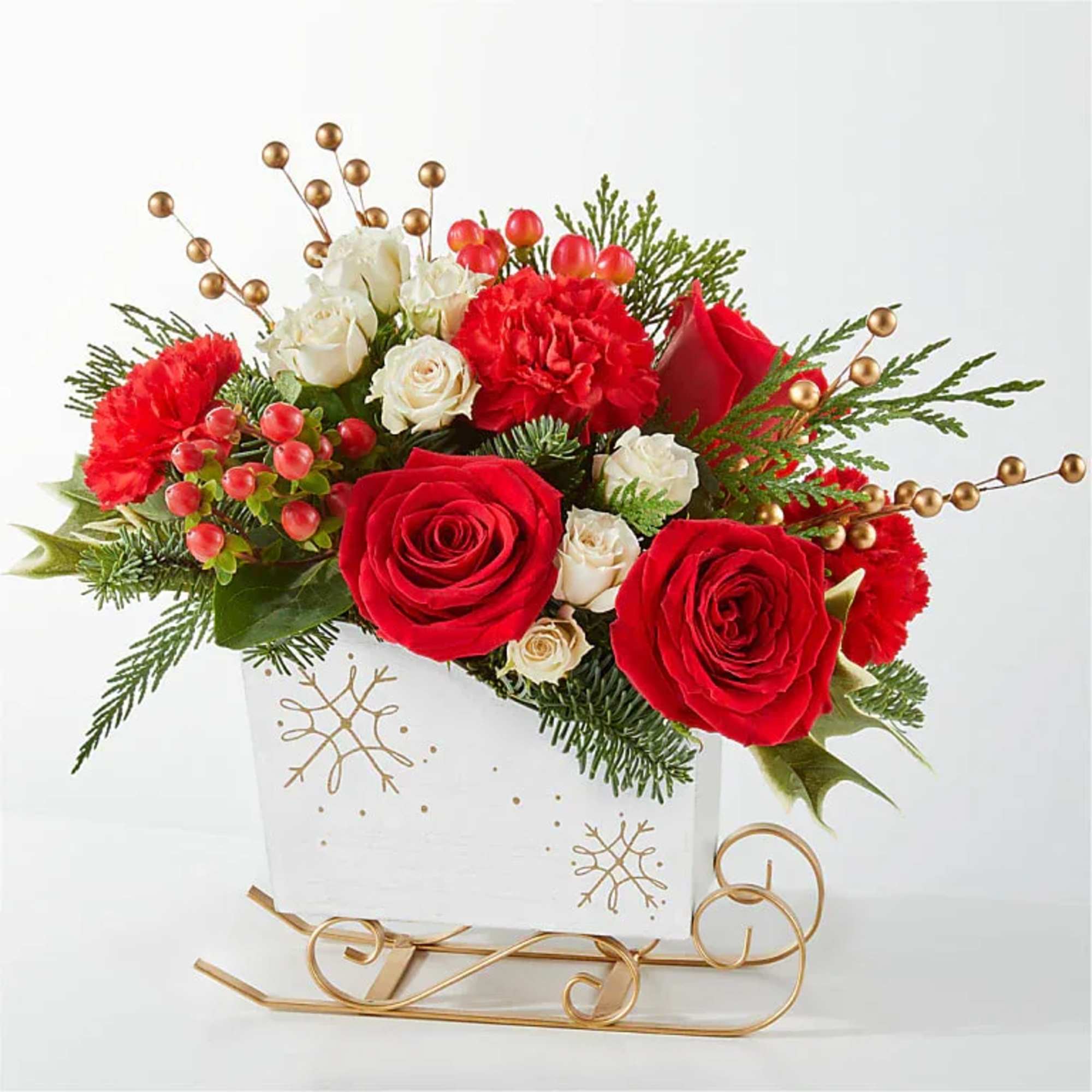 Red and white roses arranged in a white holiday container