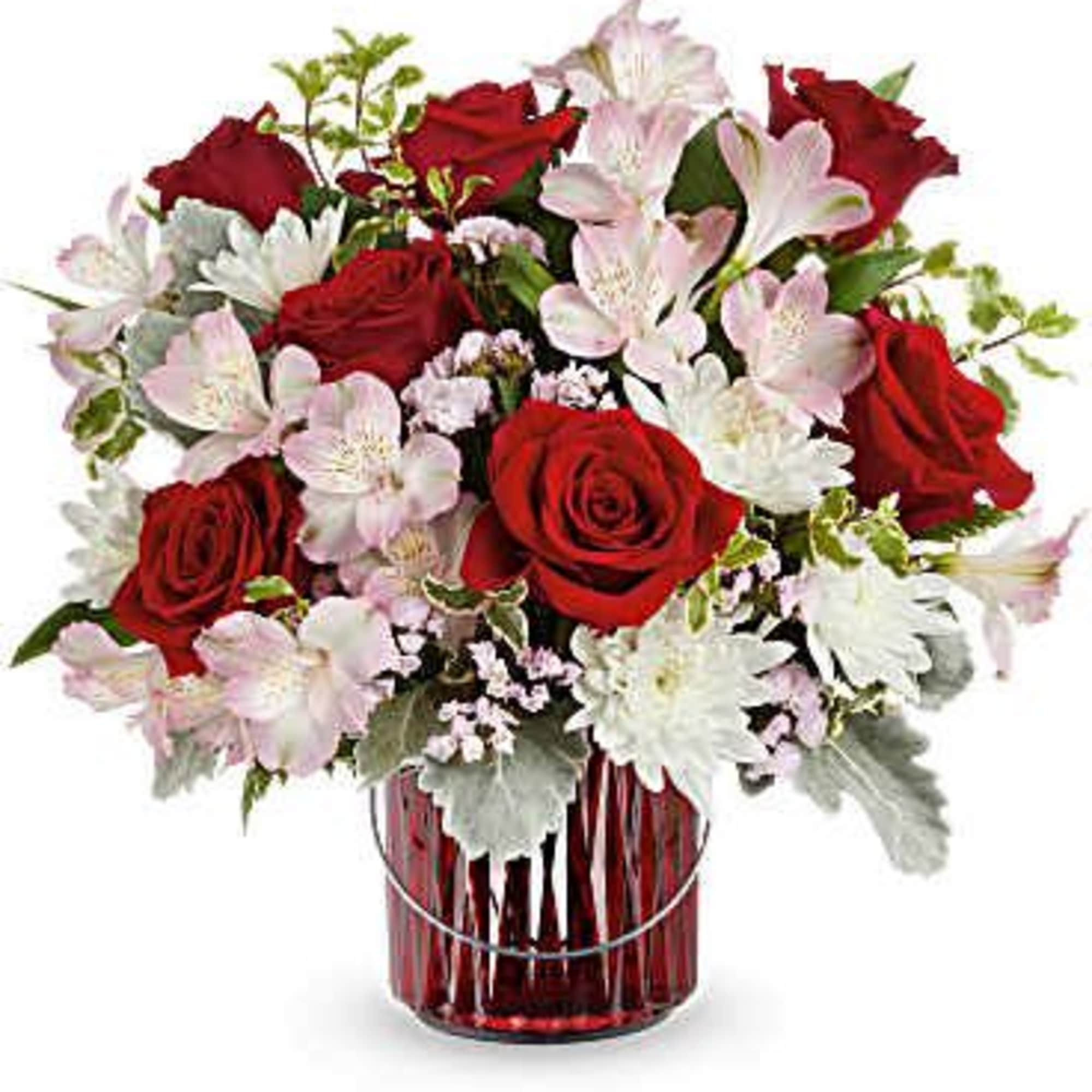 Red roses and pale pink flowers in a red glass vase