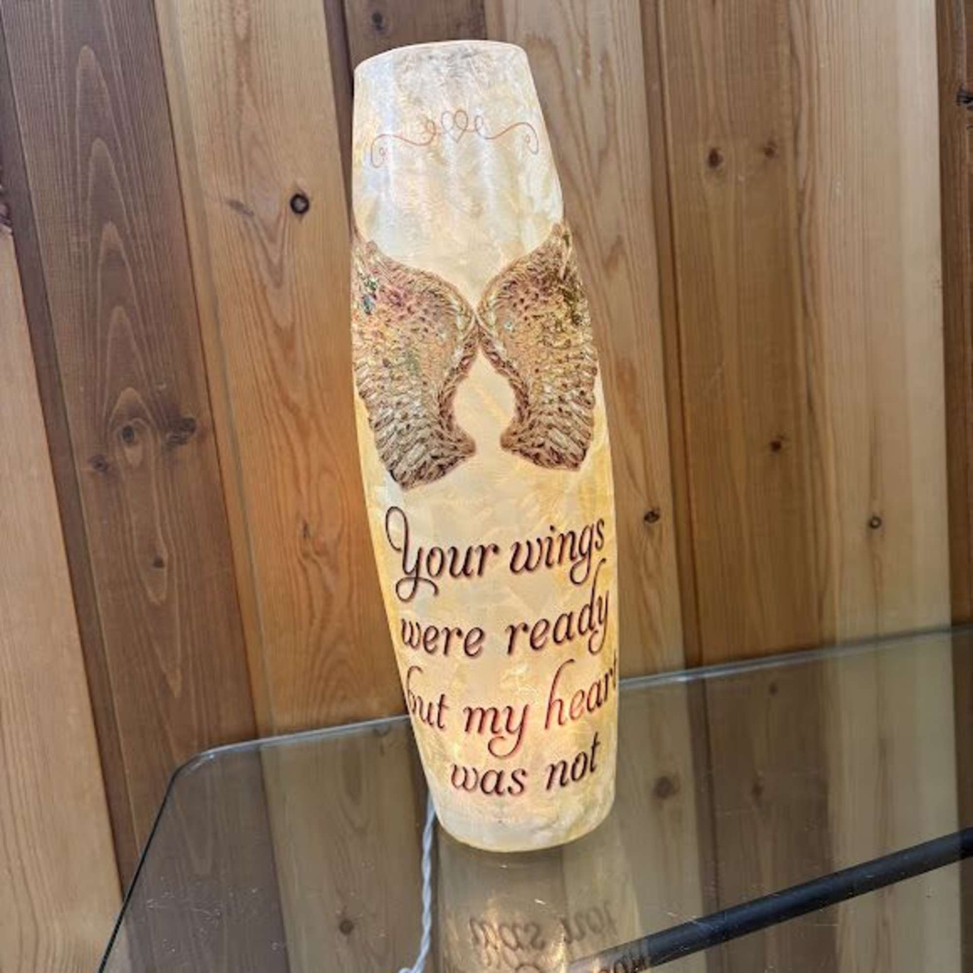 Decorative memorial candle with angel wings and a sentimental message