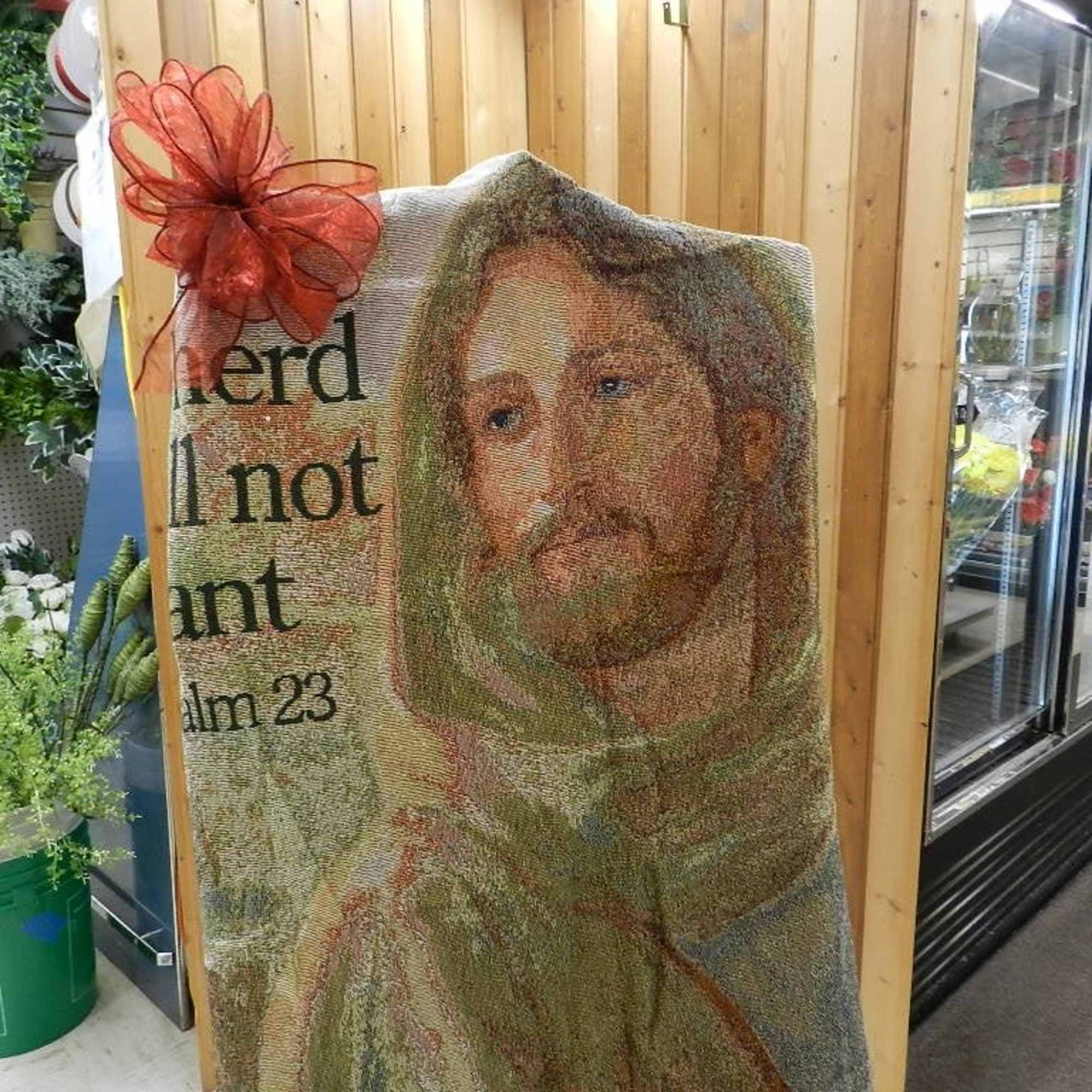 Religious tapestry with a portrait of Jesus and a red bow