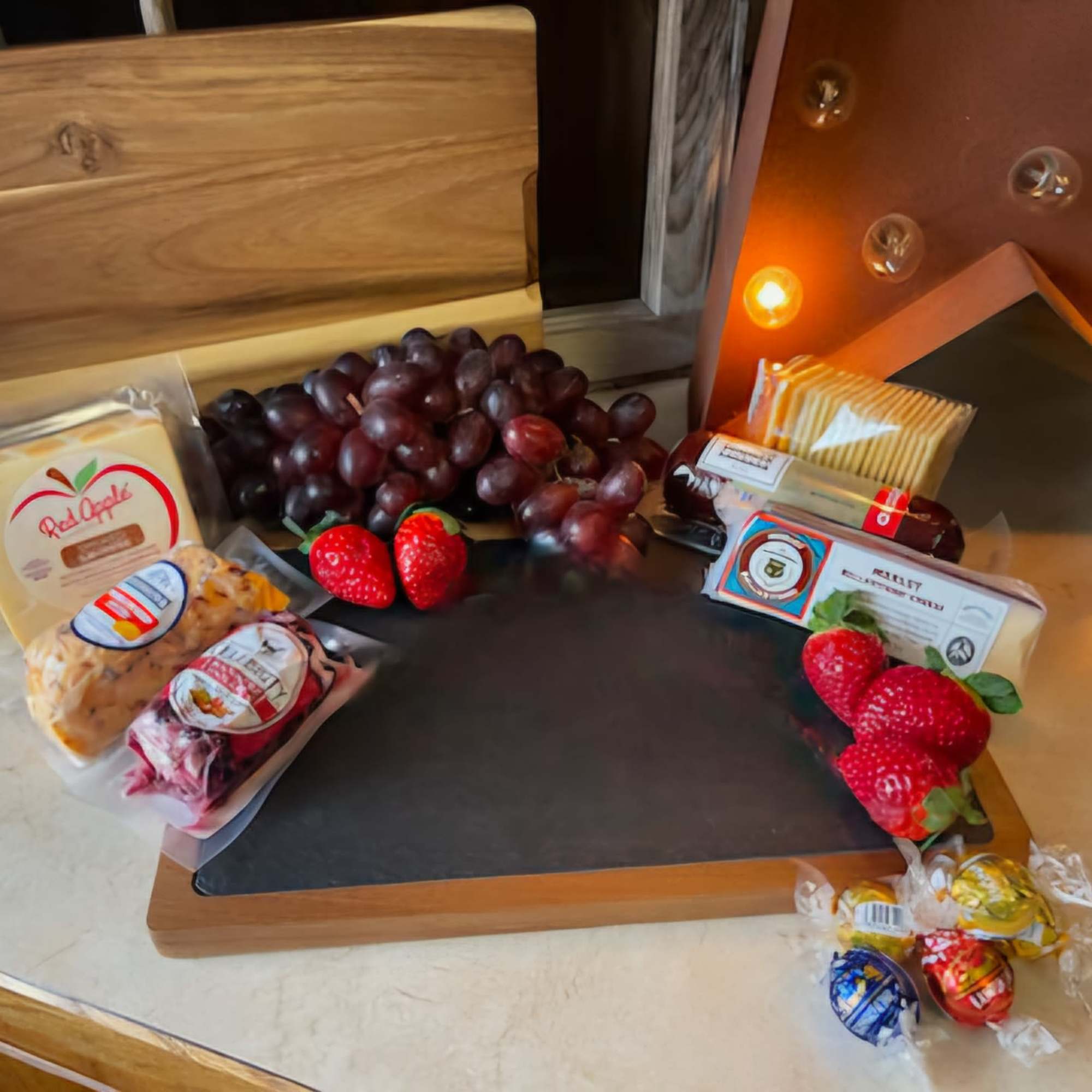 Gift tray with grapes, strawberries, cheese, crackers, and wrapped candies