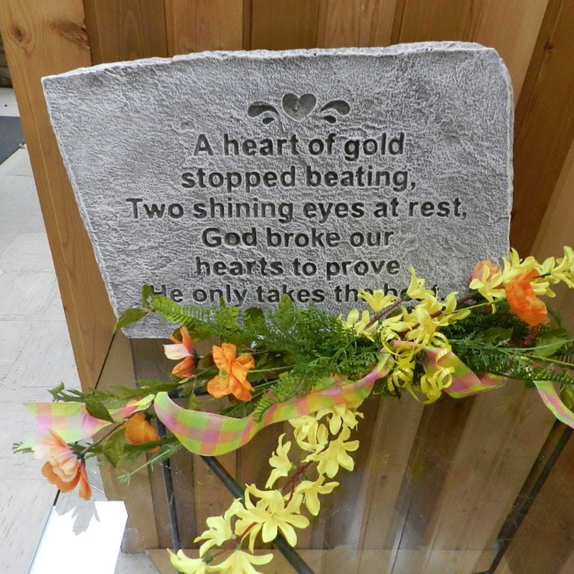 Memorial plaque with an orange and yellow floral spray