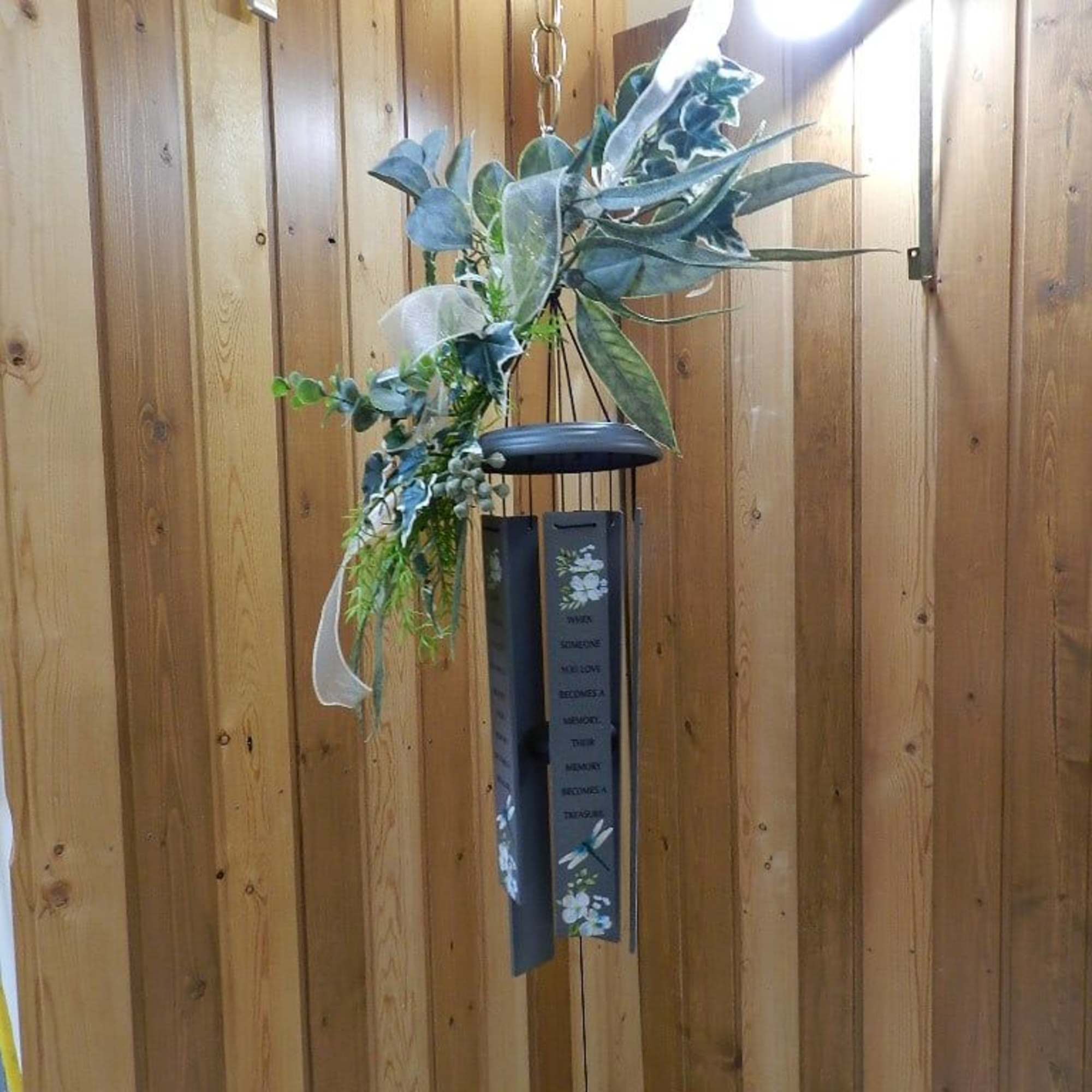 Hanging wind chime with faux greenery and a black metal top