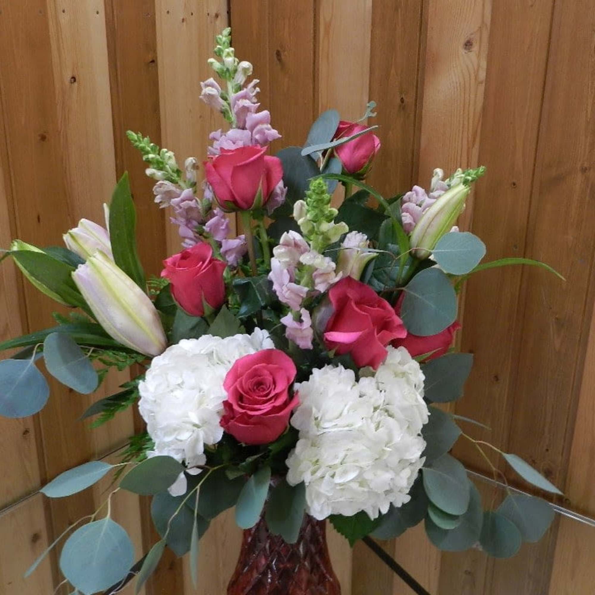 Bouquet of pink roses, white hydrangeas, and lilies in a vase