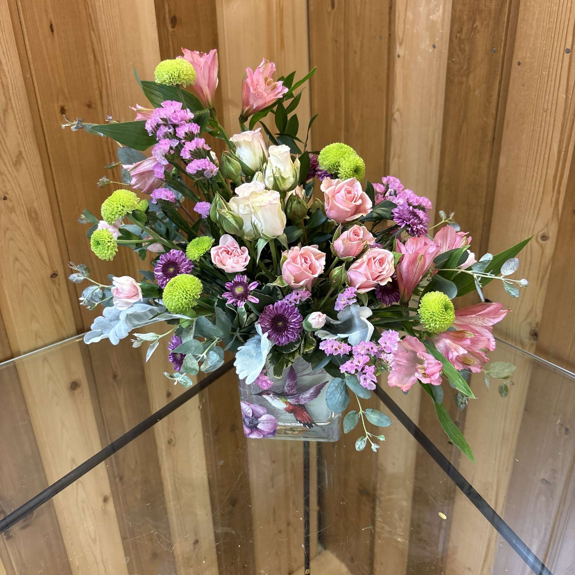 Mixed pink and purple bouquet in a square glass vase