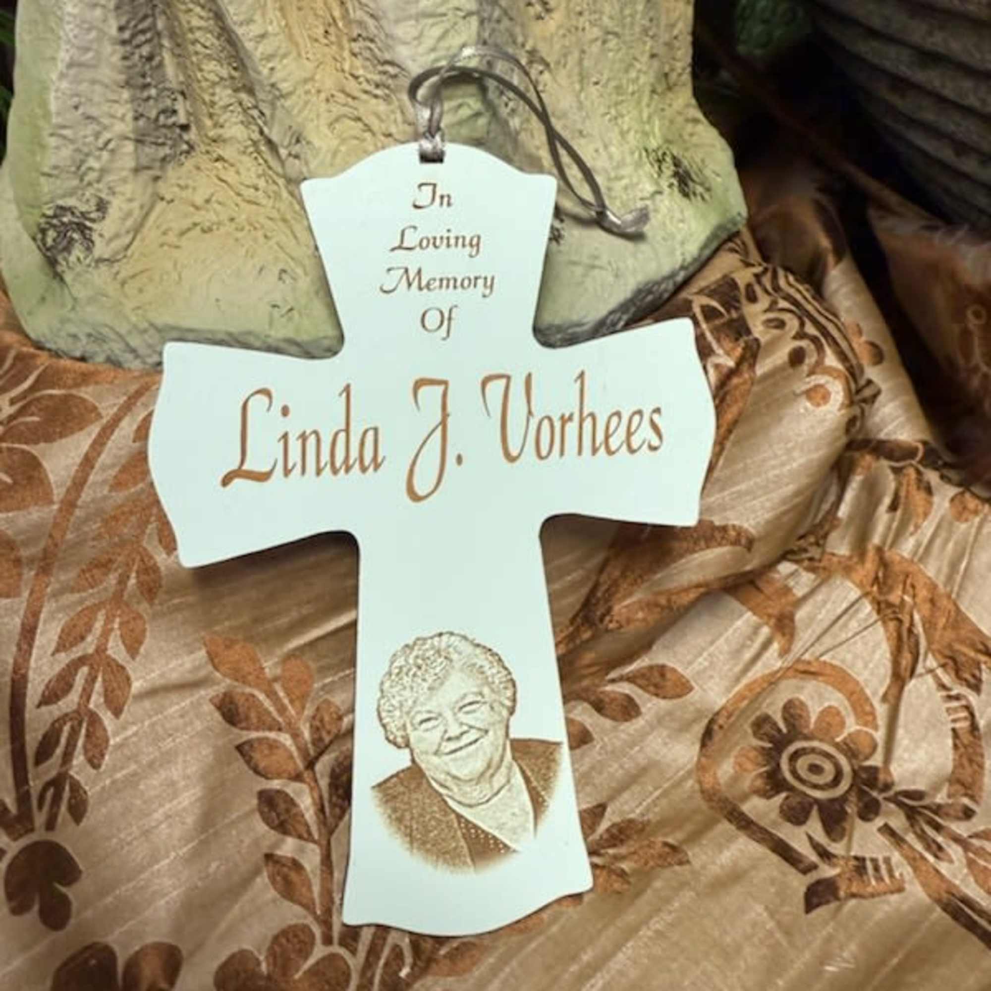 White memorial cross ornament with a portrait and name inscription