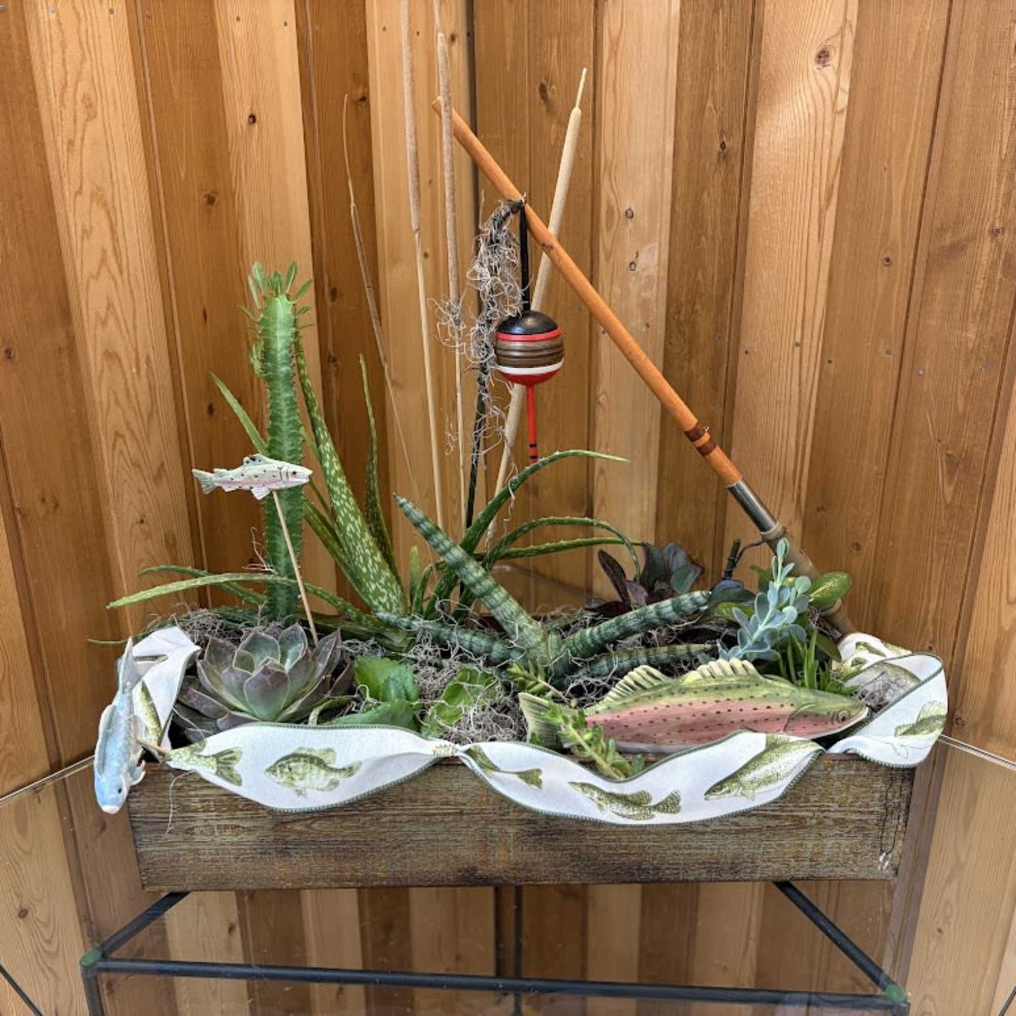 Succulent planter in a wooden box with fishing-themed decorations