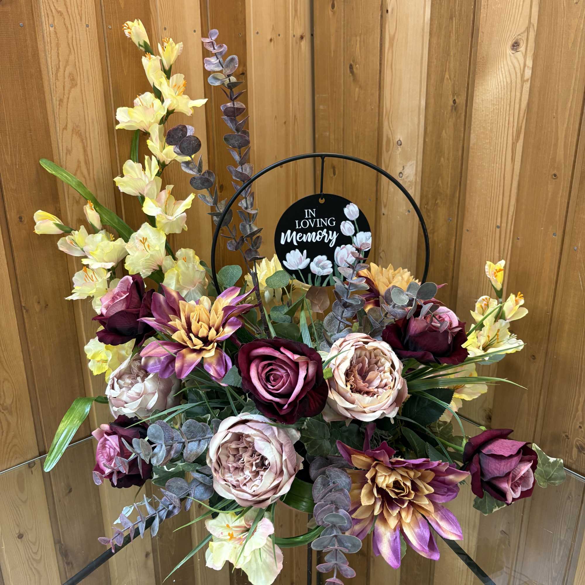 Sympathy floral arrangement with roses and lilies on a memorial stand