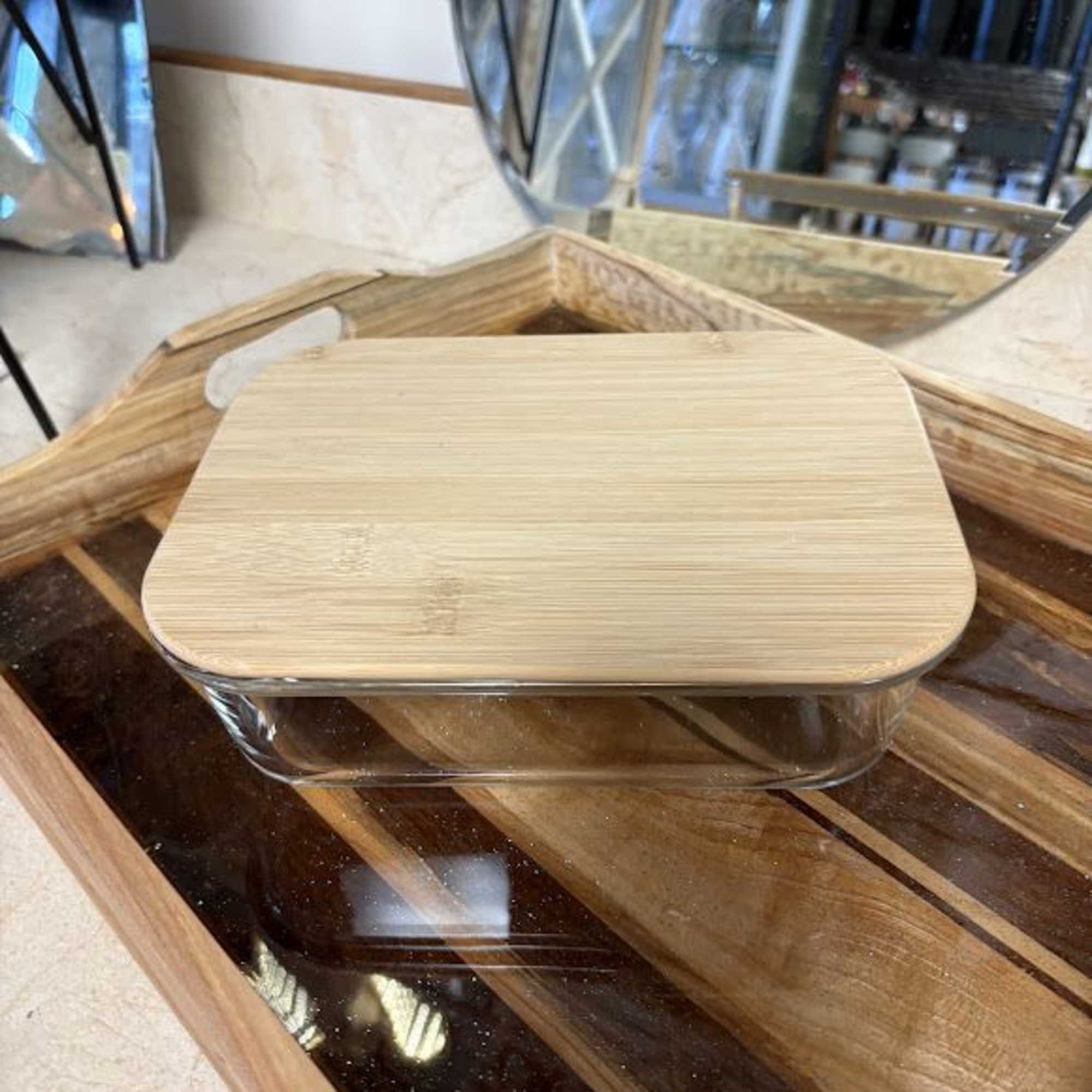 Rectangular glass container with a bamboo lid on a wooden tray