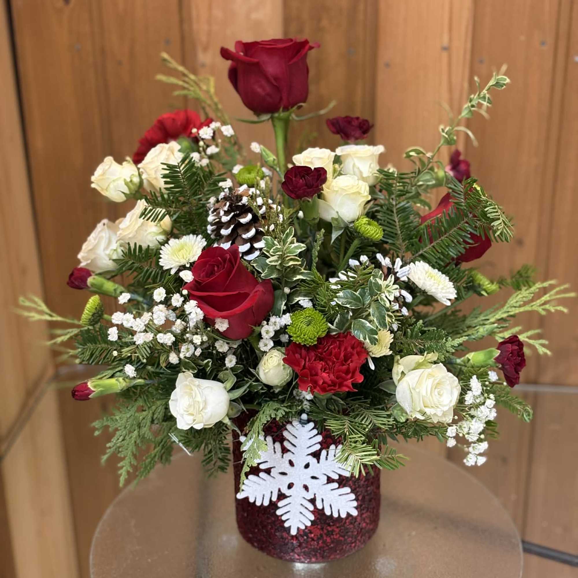 Red and white roses in a glittery vase with a snowflake decoration