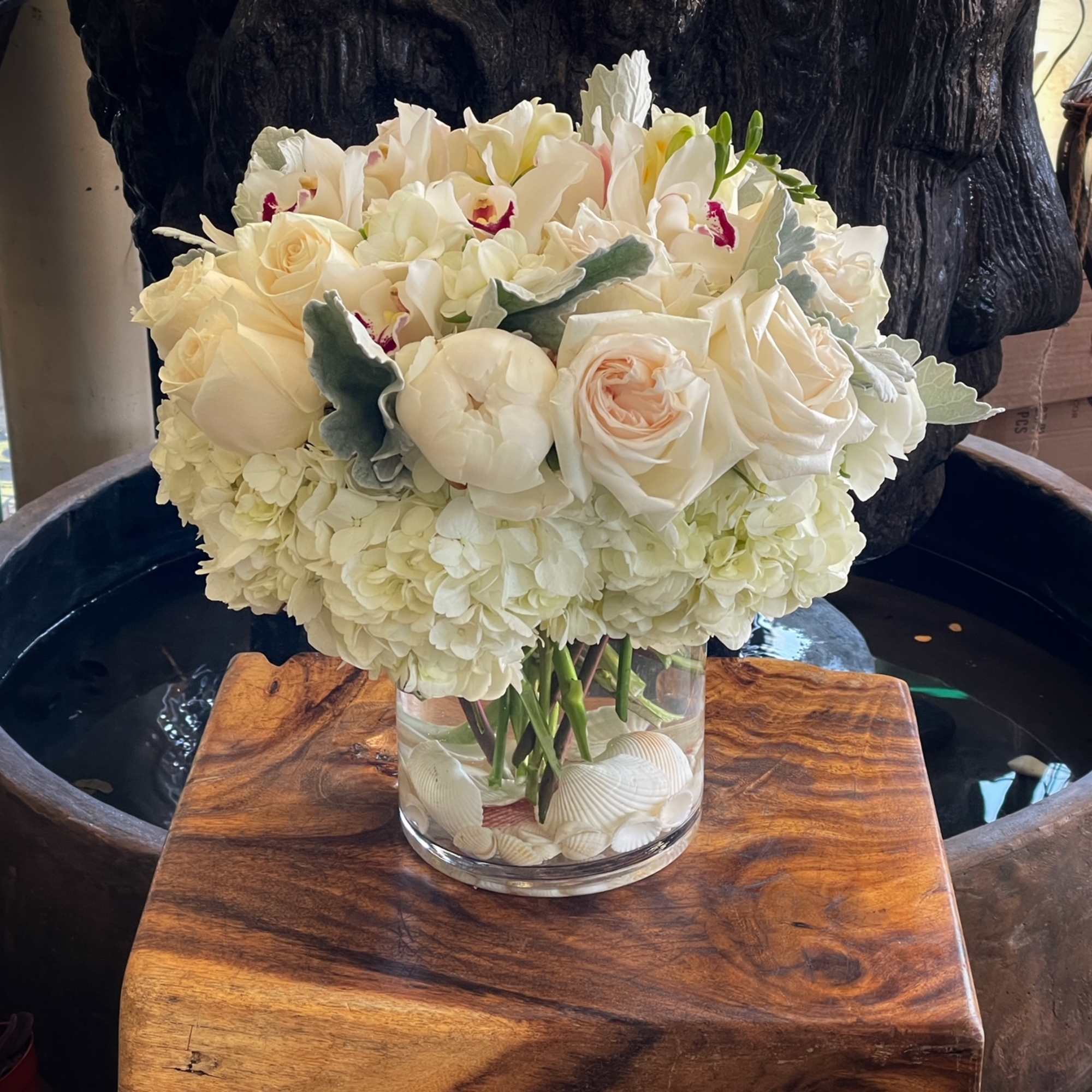 White rose and orchid bouquet in a clear glass vase