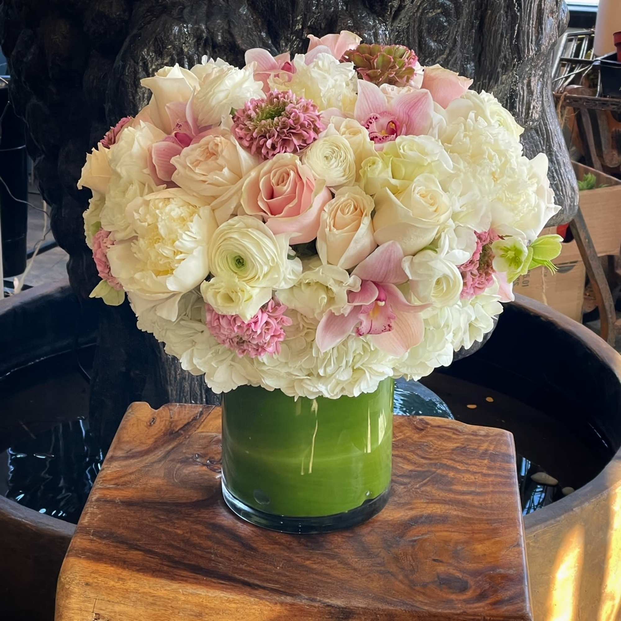 Bouquet of pale pink and white flowers in a green glass vase