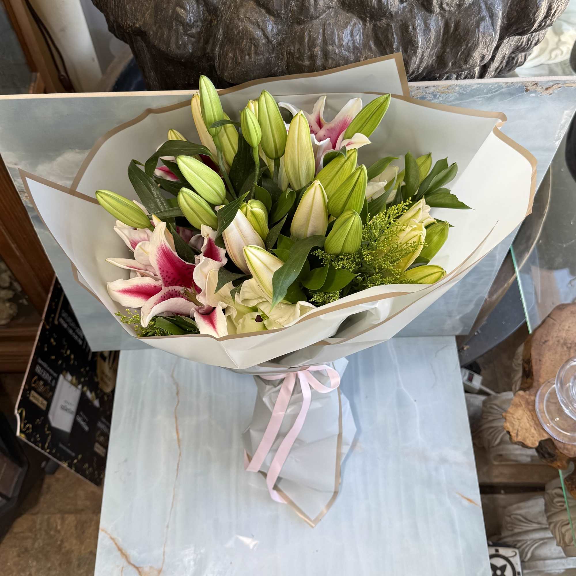 A graceful wrap bouquet featuring fragrant pink-and-white stargazer lilies surrounded by lush
