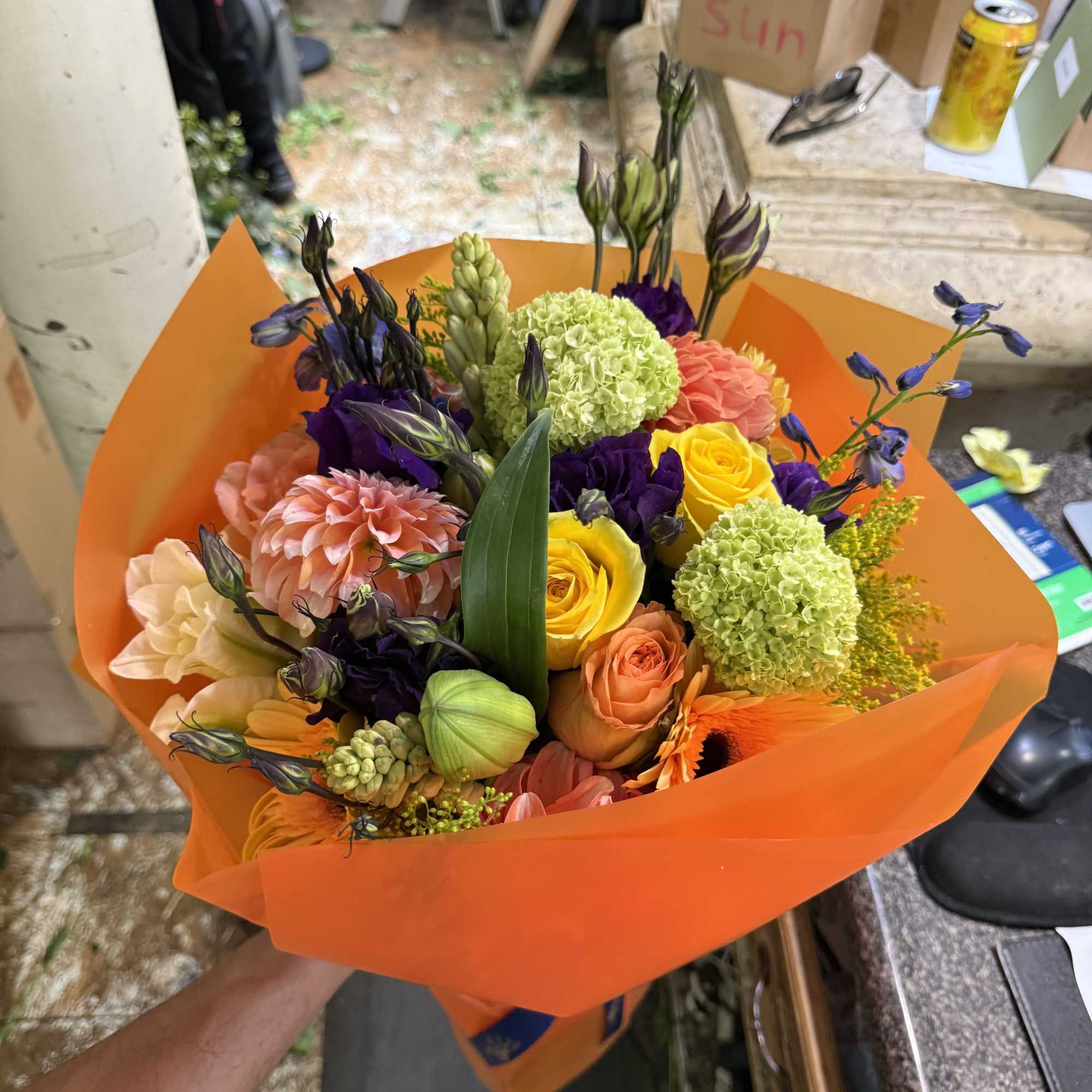 This bouquet is a vibrant celebration of color and texture, artfully wrapped