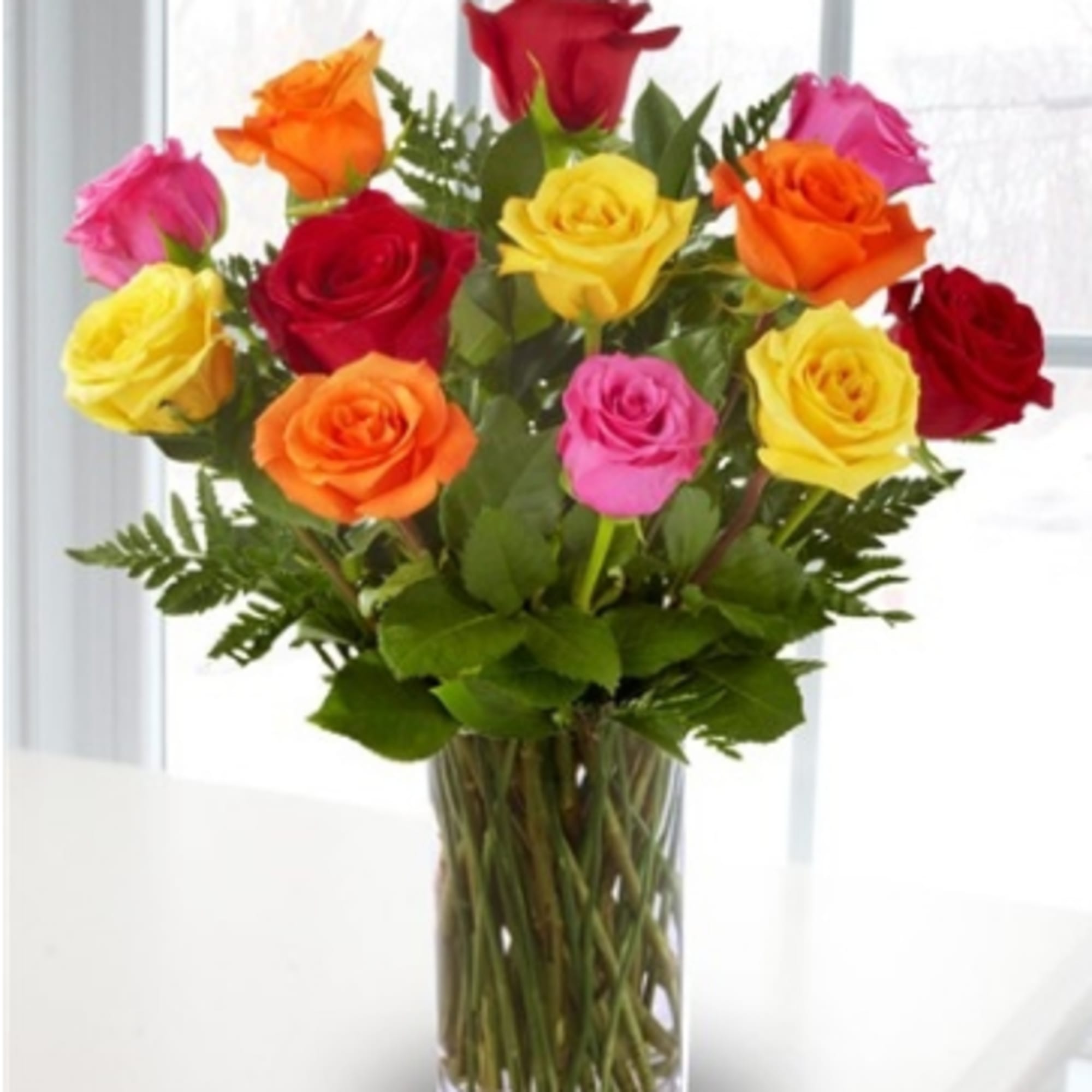 Colorful roses arranged in a clear glass vase