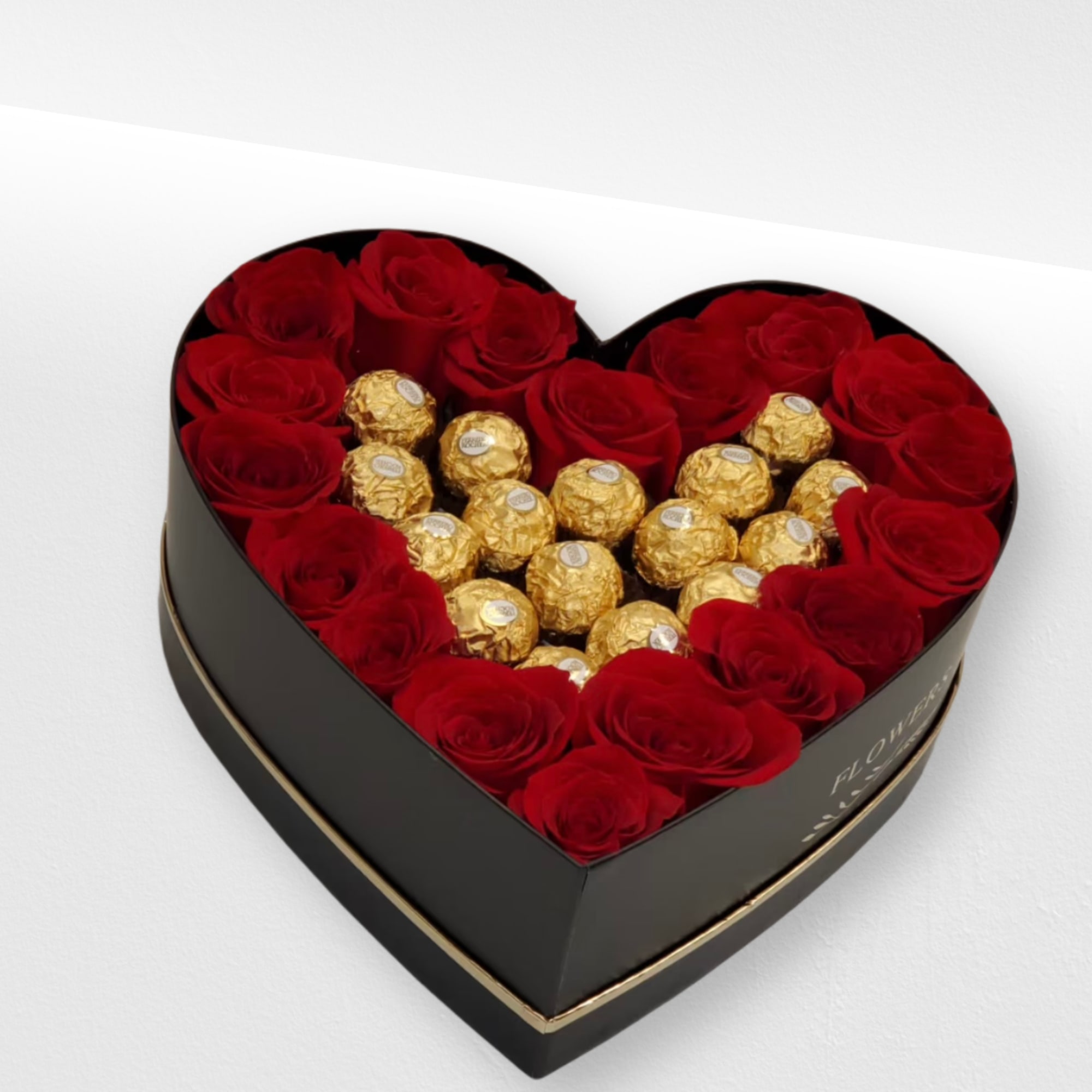 Heart-shaped black box filled with red roses and gold-wrapped chocolates