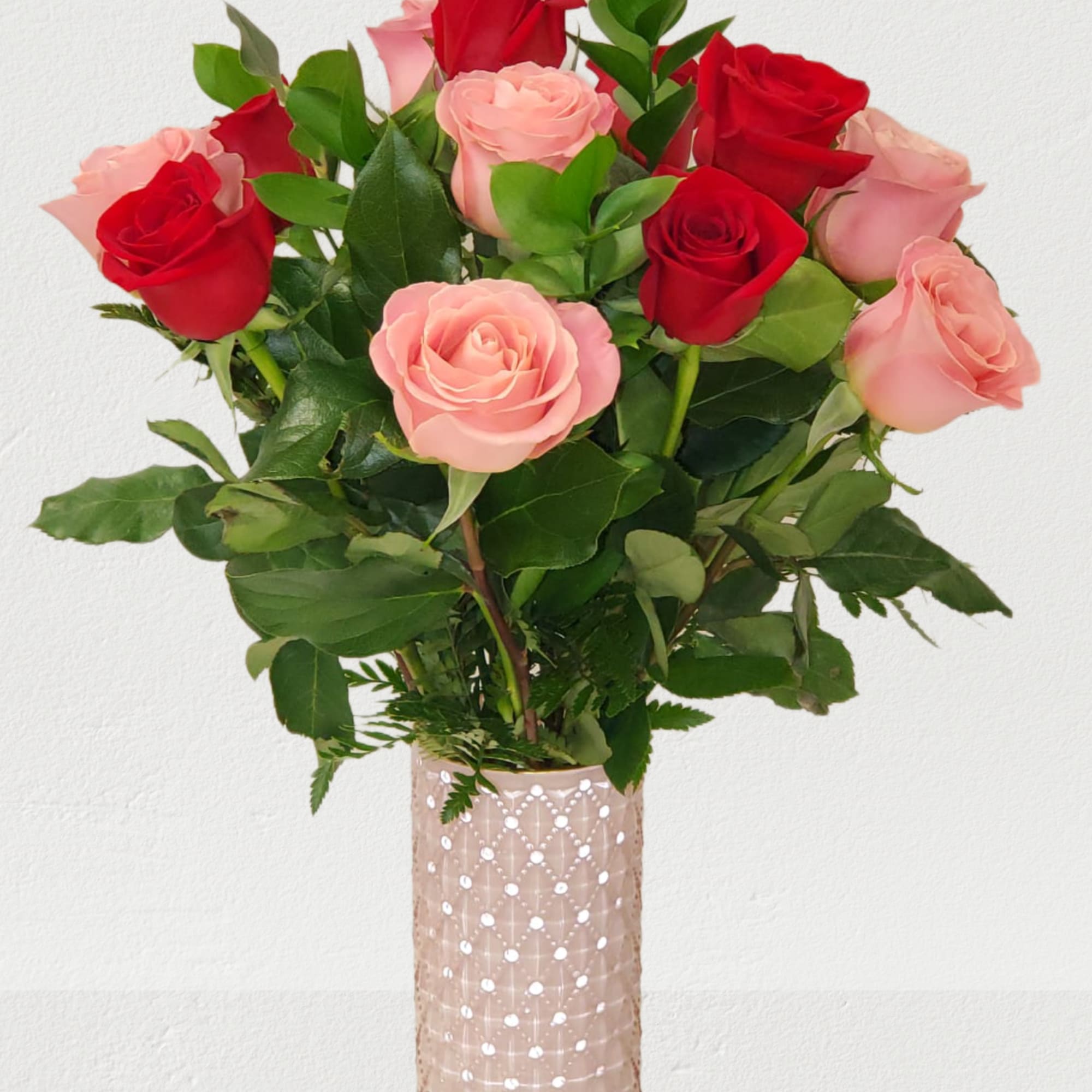 Bouquet of red and pink roses in a tall glass vase