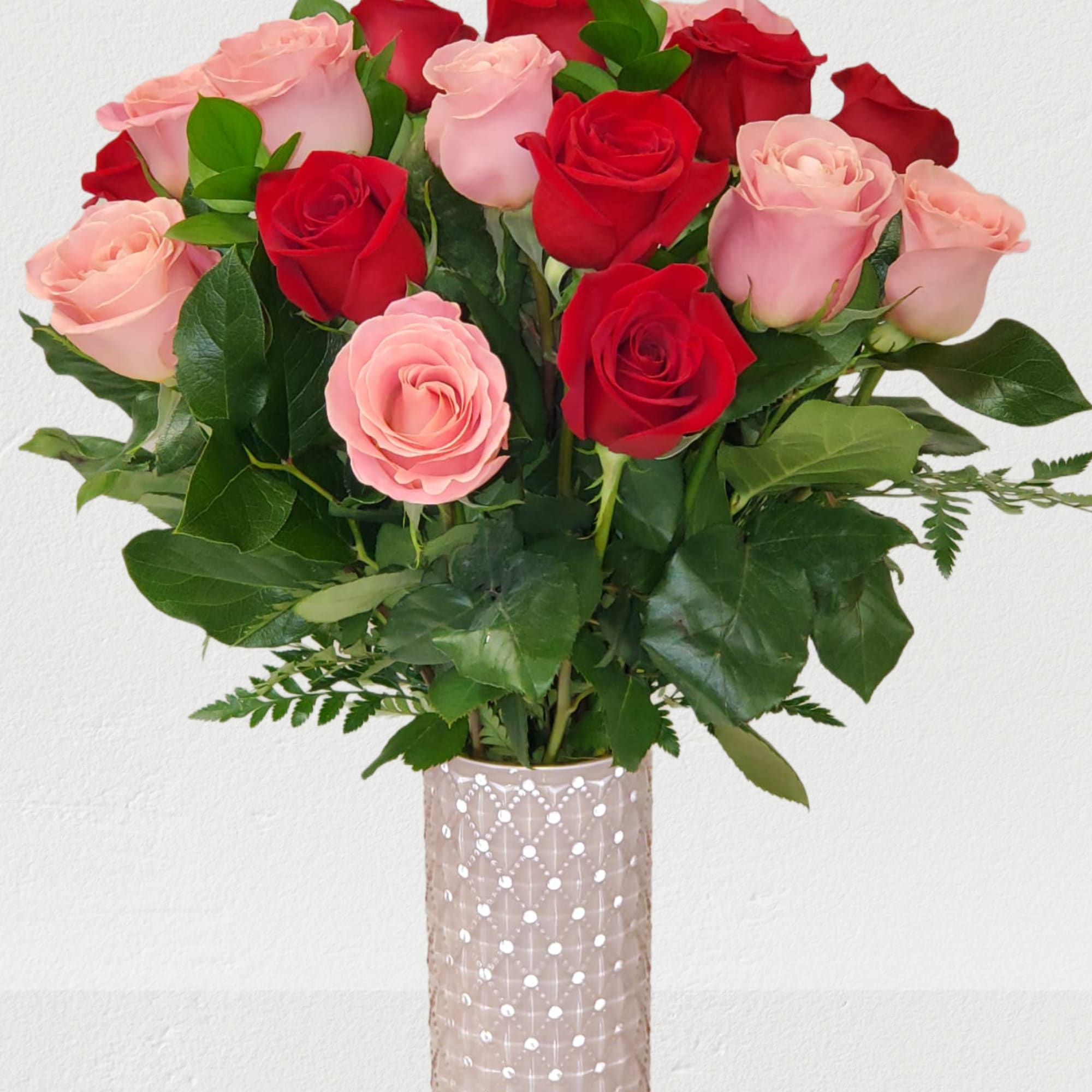 Bouquet of red and pink roses in a patterned glass vase
