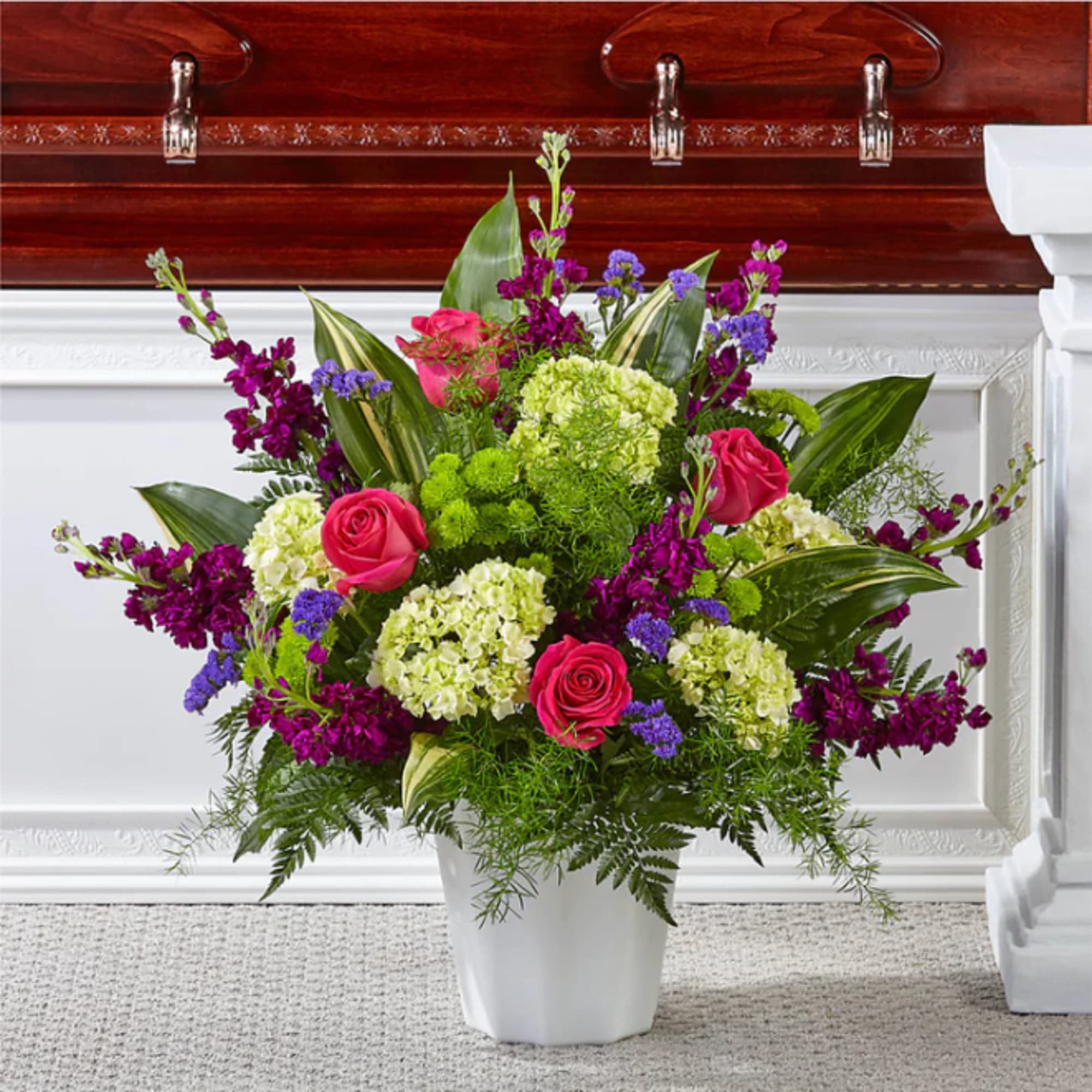 Pink roses and purple flowers in a white vase
