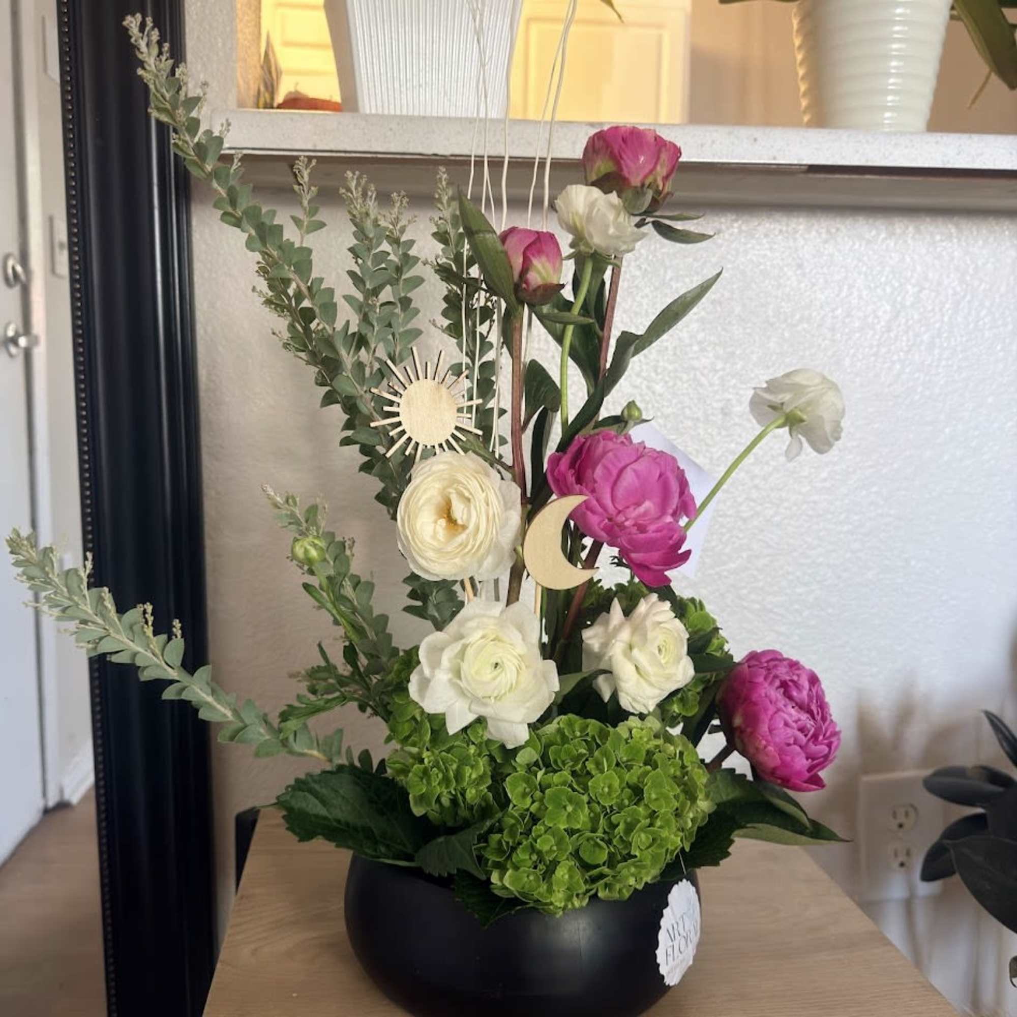 An elegant ikebana arrangement featuring the delicate beauty of peonies, the charming