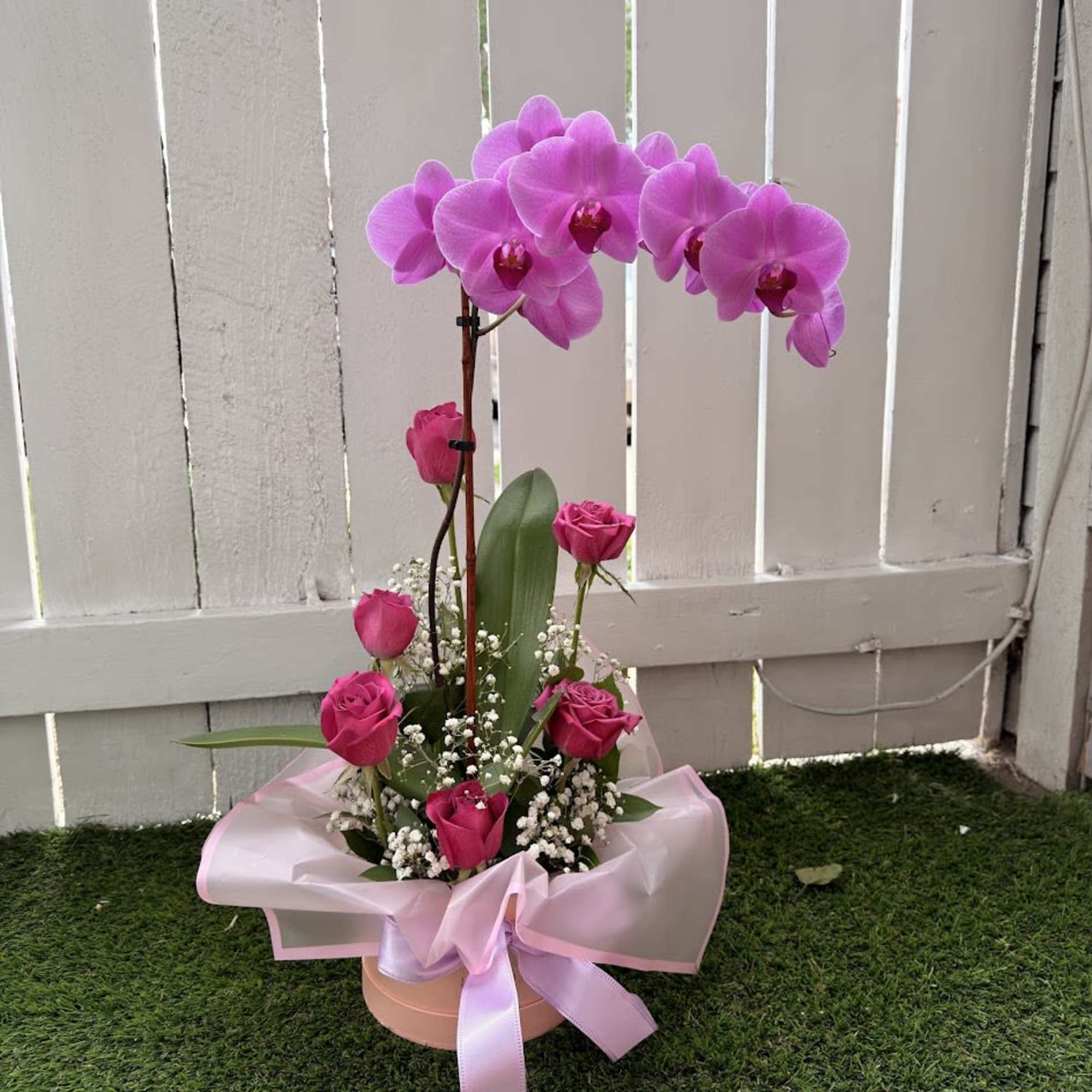 An elegant floral arrangement designed in a pink box, featuring a stunning