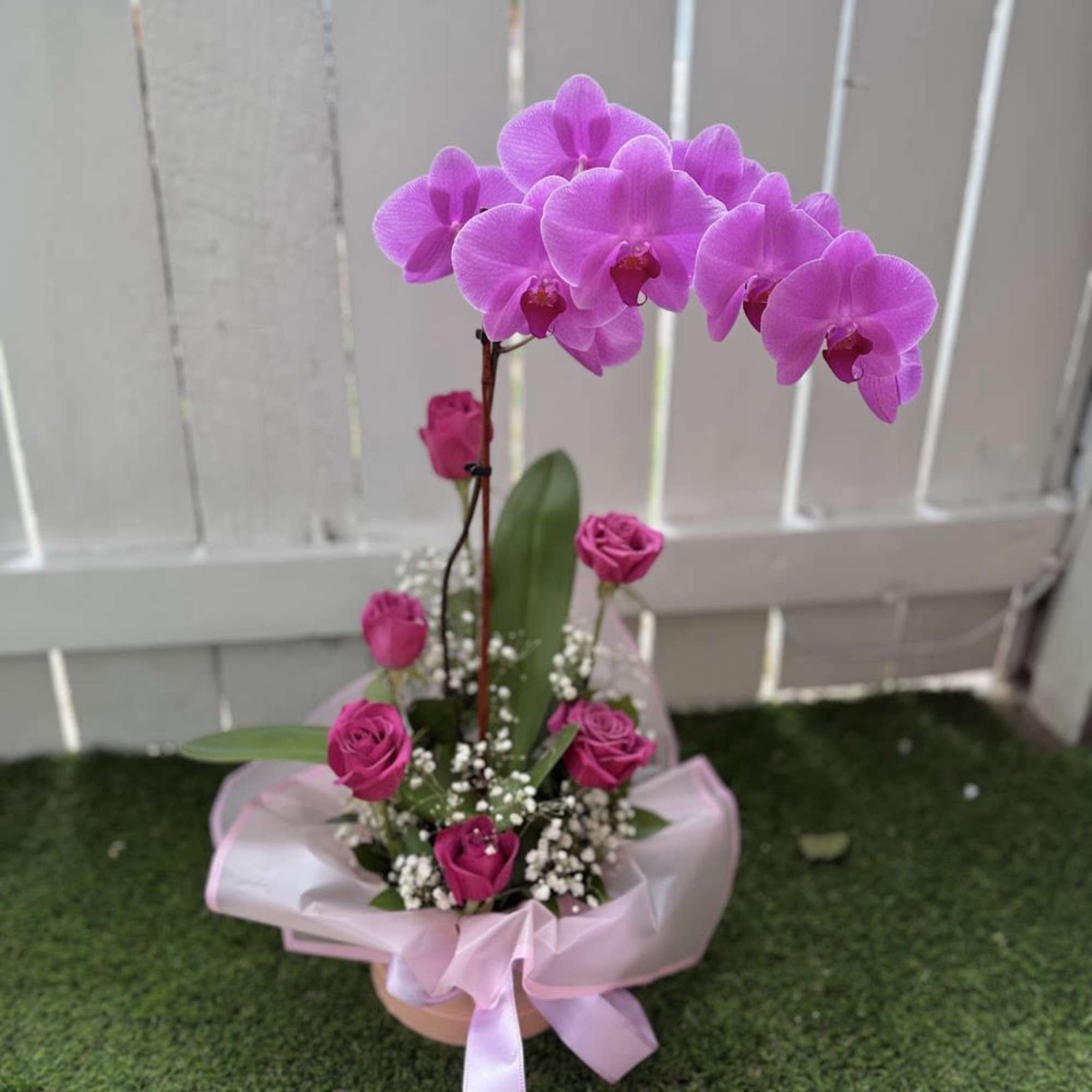 An elegant floral arrangement designed in a pink box, featuring a stunning