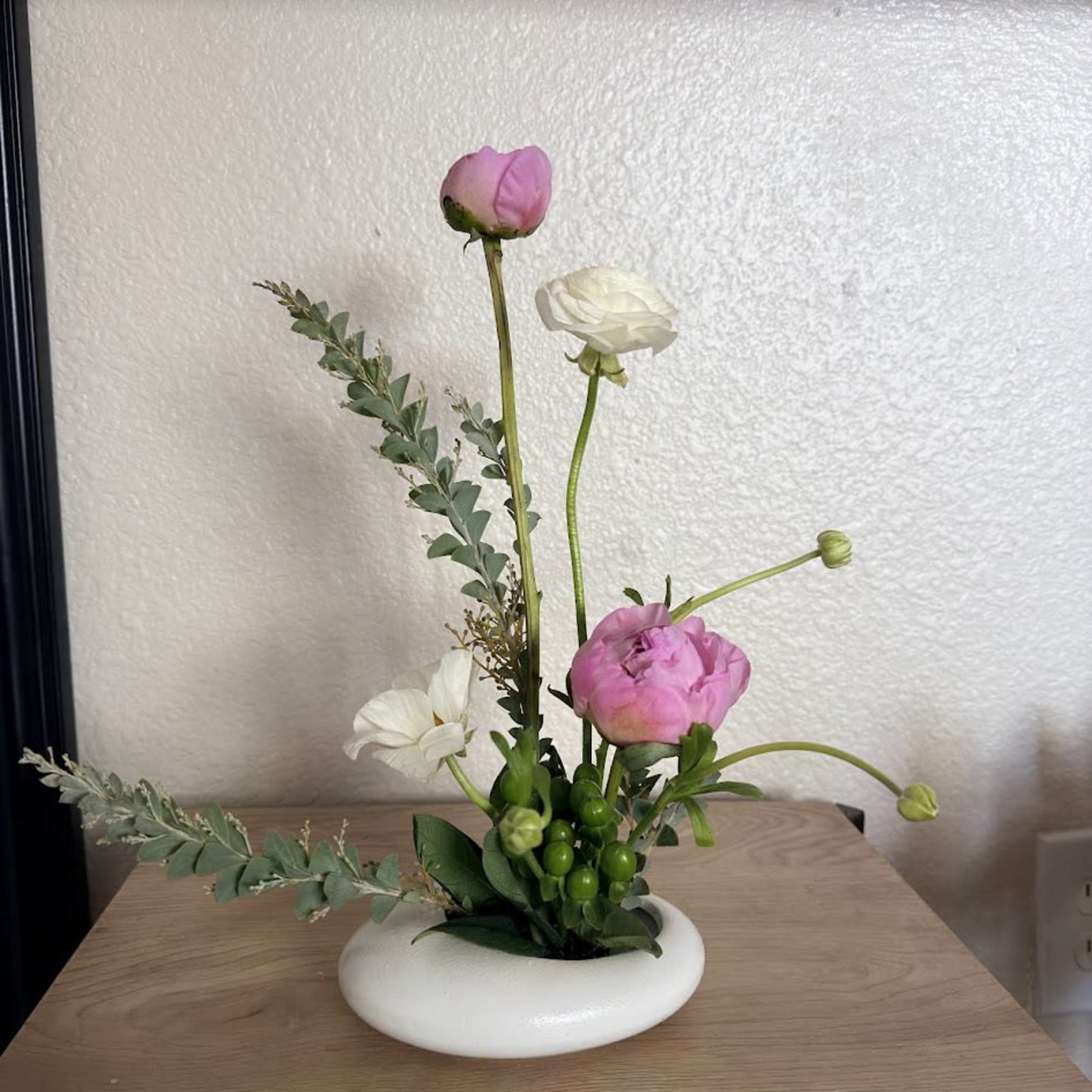 A delicate and sophisticated ikebana arrangement designed to capture the essence of
