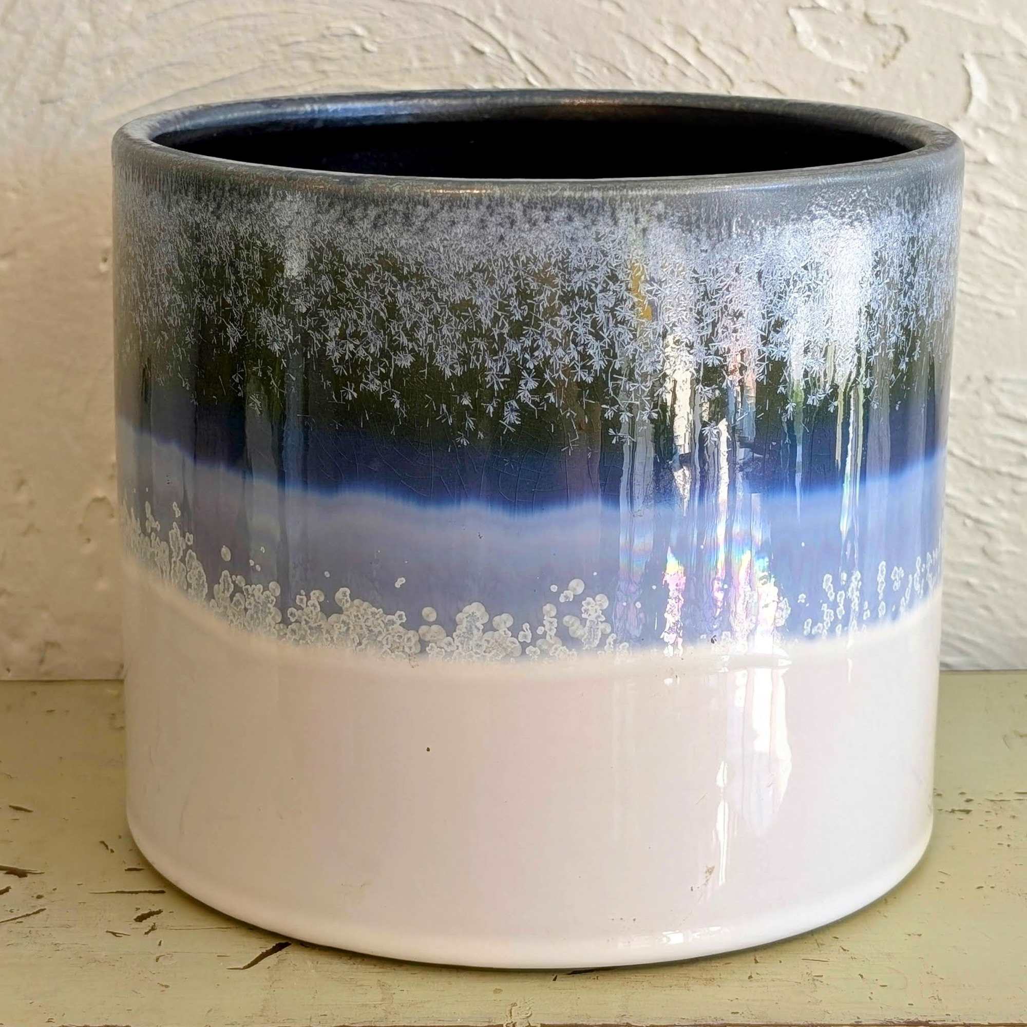 Round ceramic planter with glossy white base and blue and gray crystalline glaze near the rim