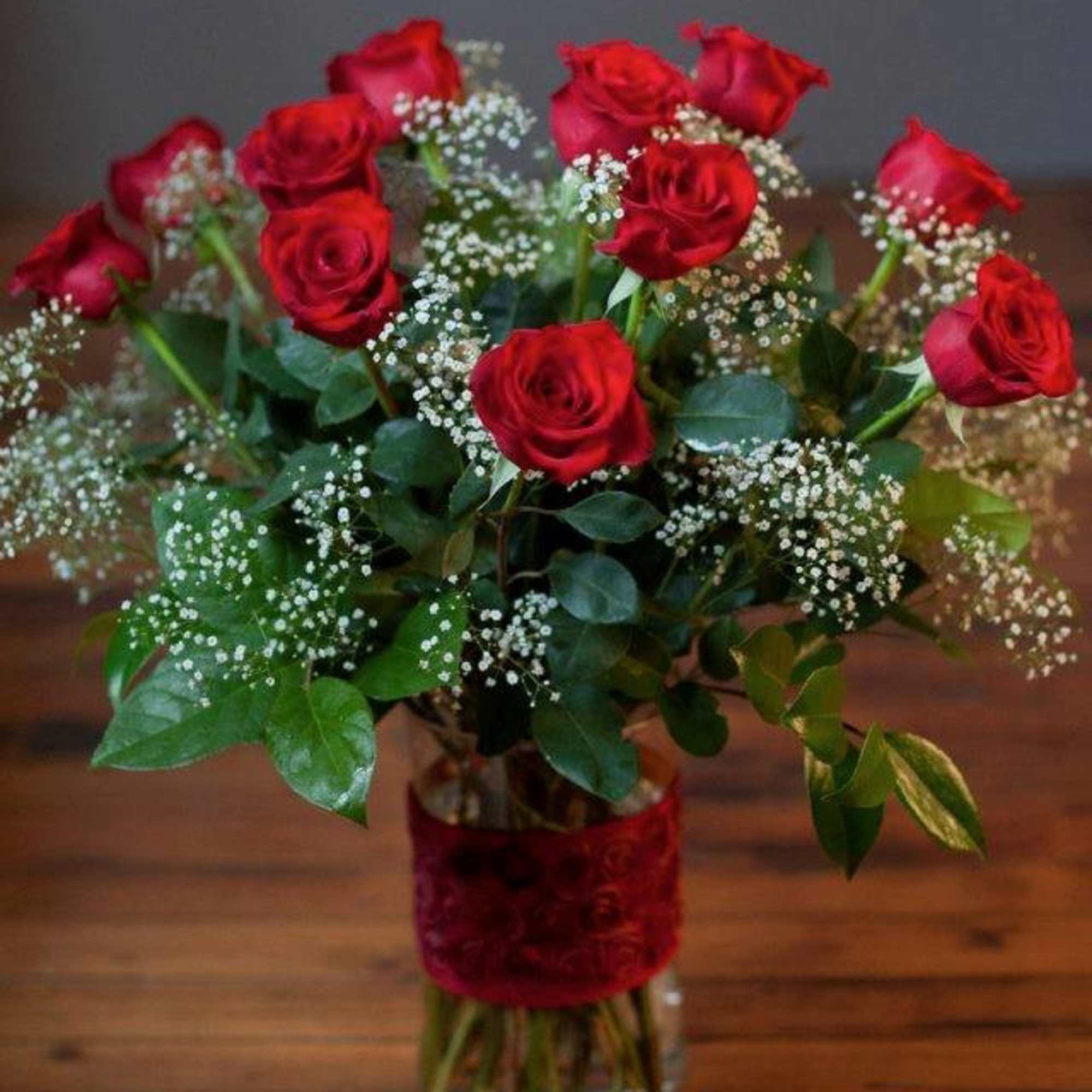 Premium long stem red roses in a cloud of Baby's Breath supported