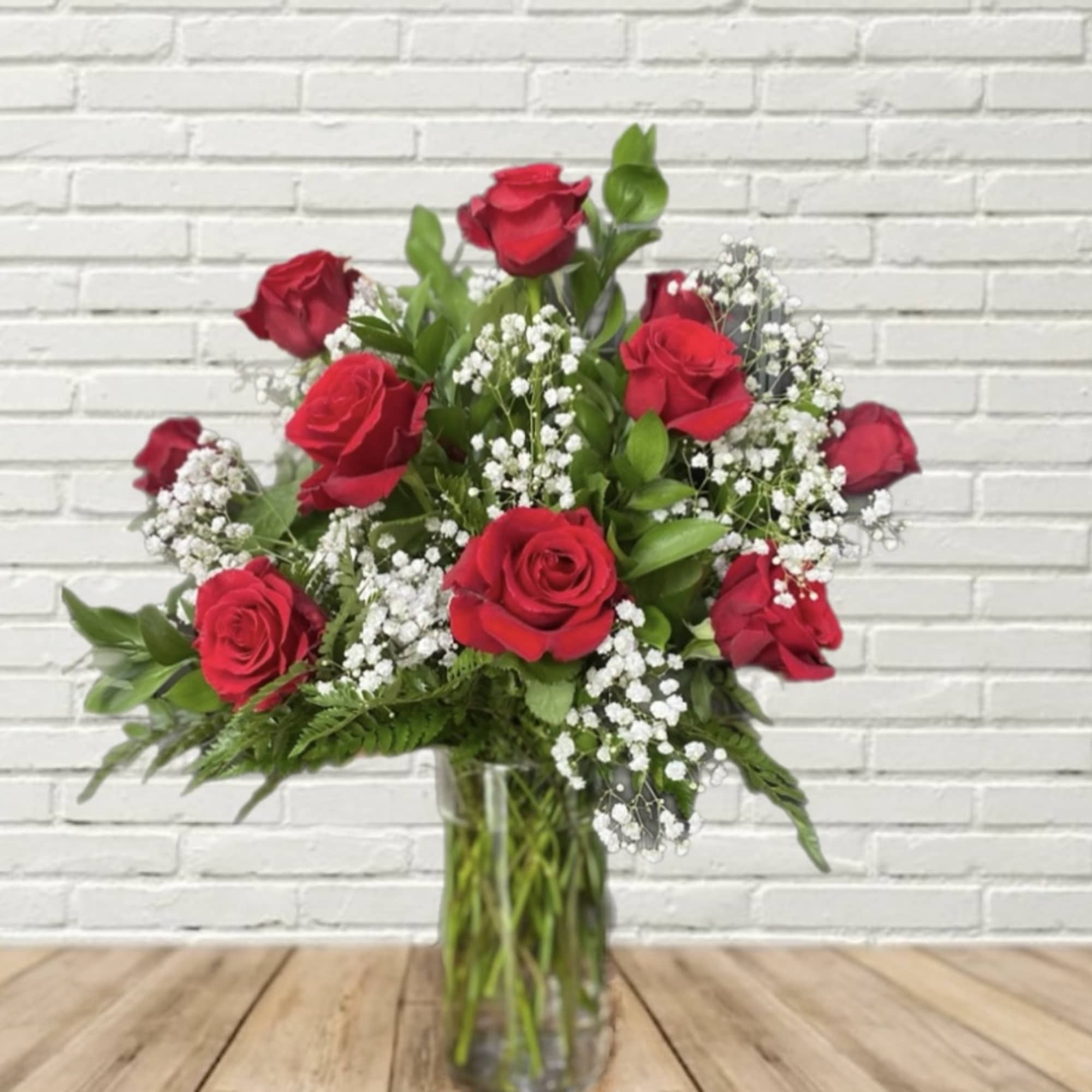 Red roses and white baby's breath in a clear glass vase