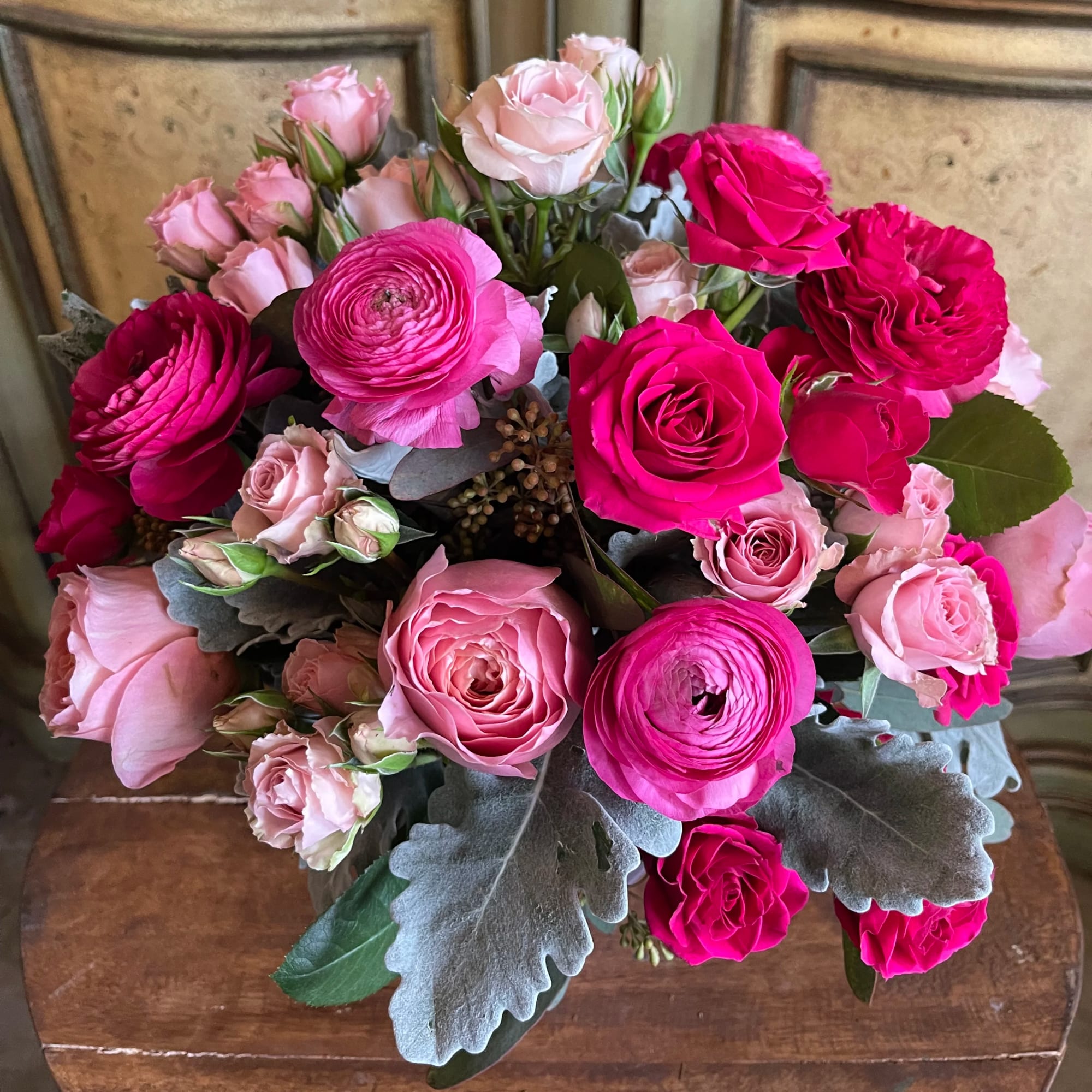 Bouquet of pink and hot pink roses with gray foliage