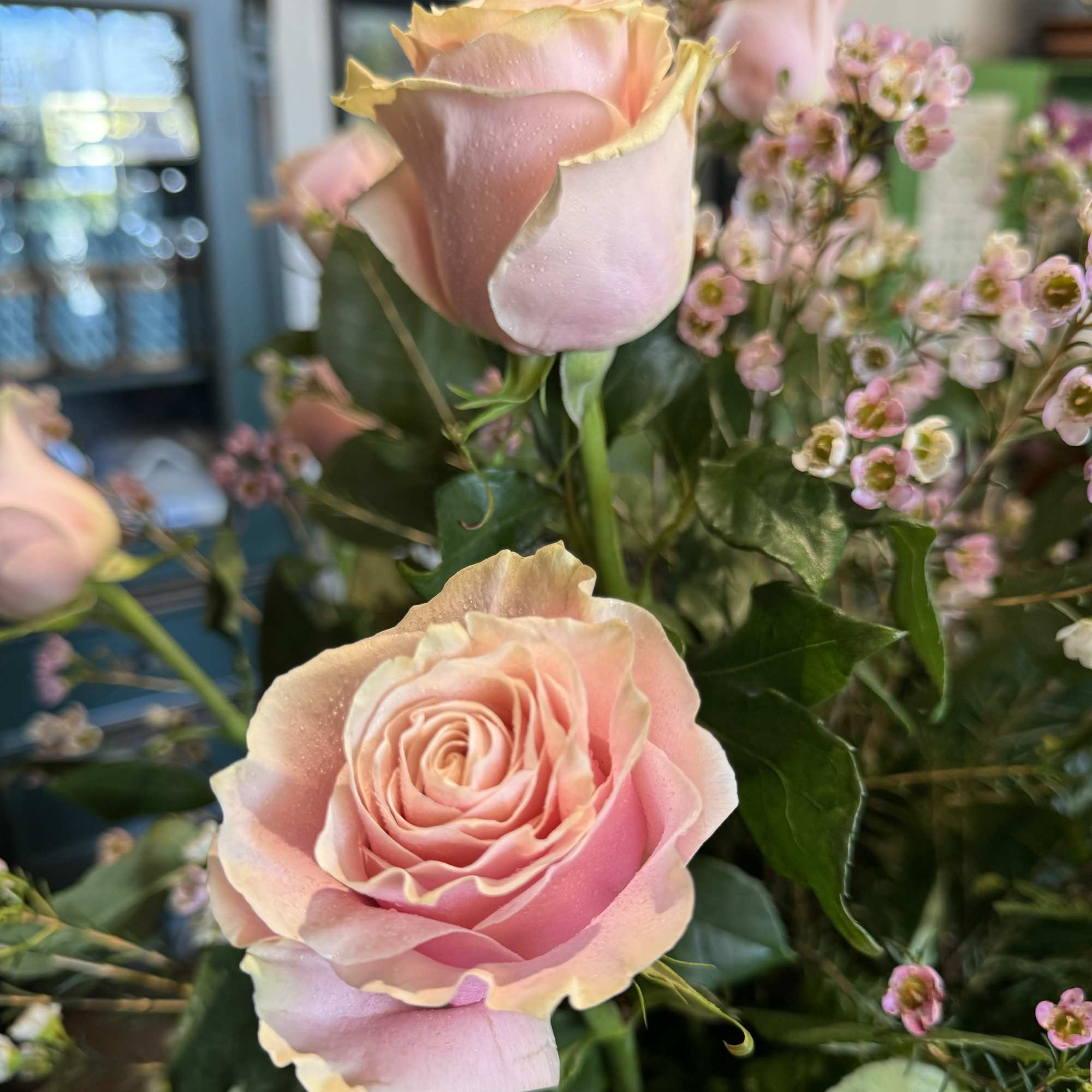 Pink roses with small pink filler flowers in a bouquet