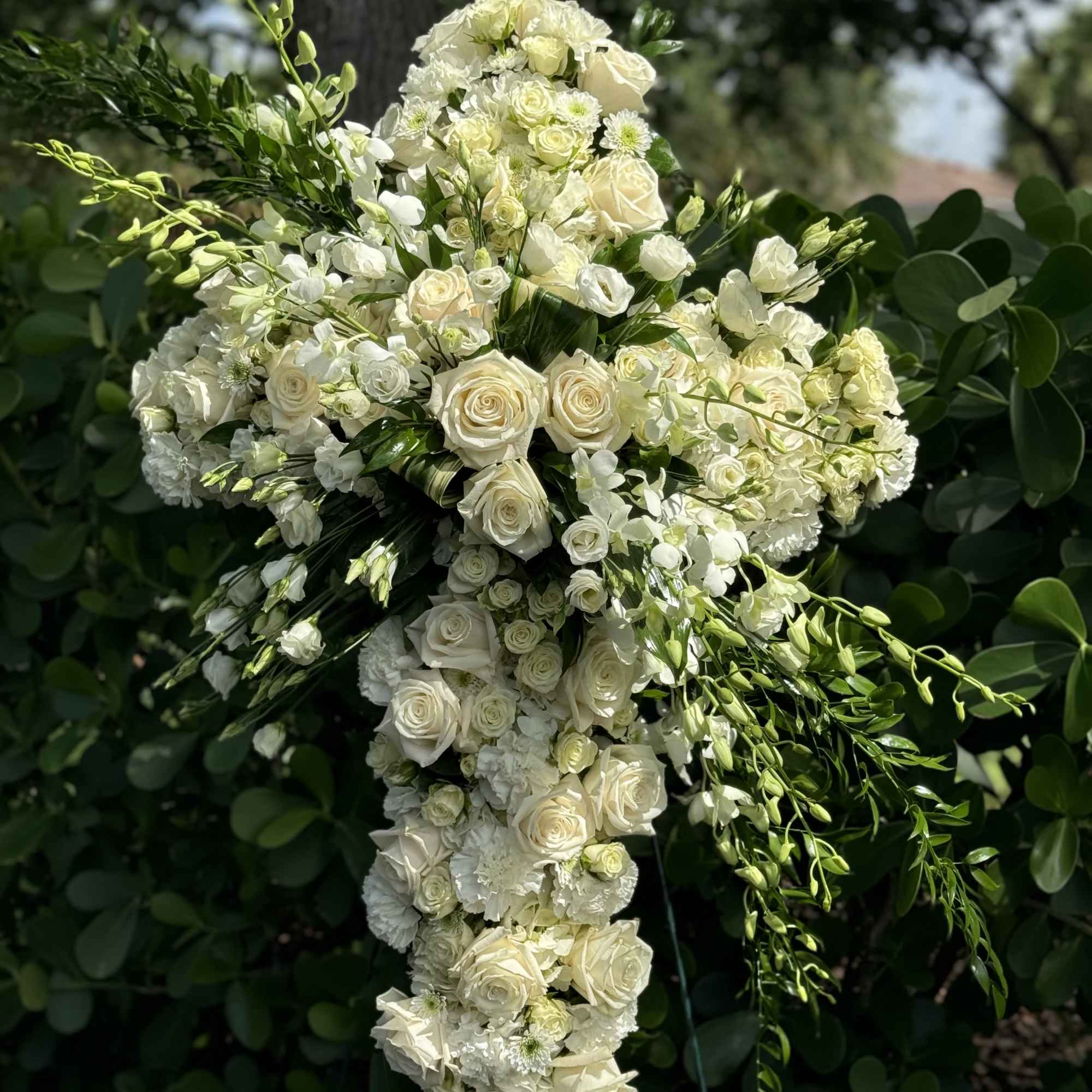 White floral cross with roses and cascading blooms