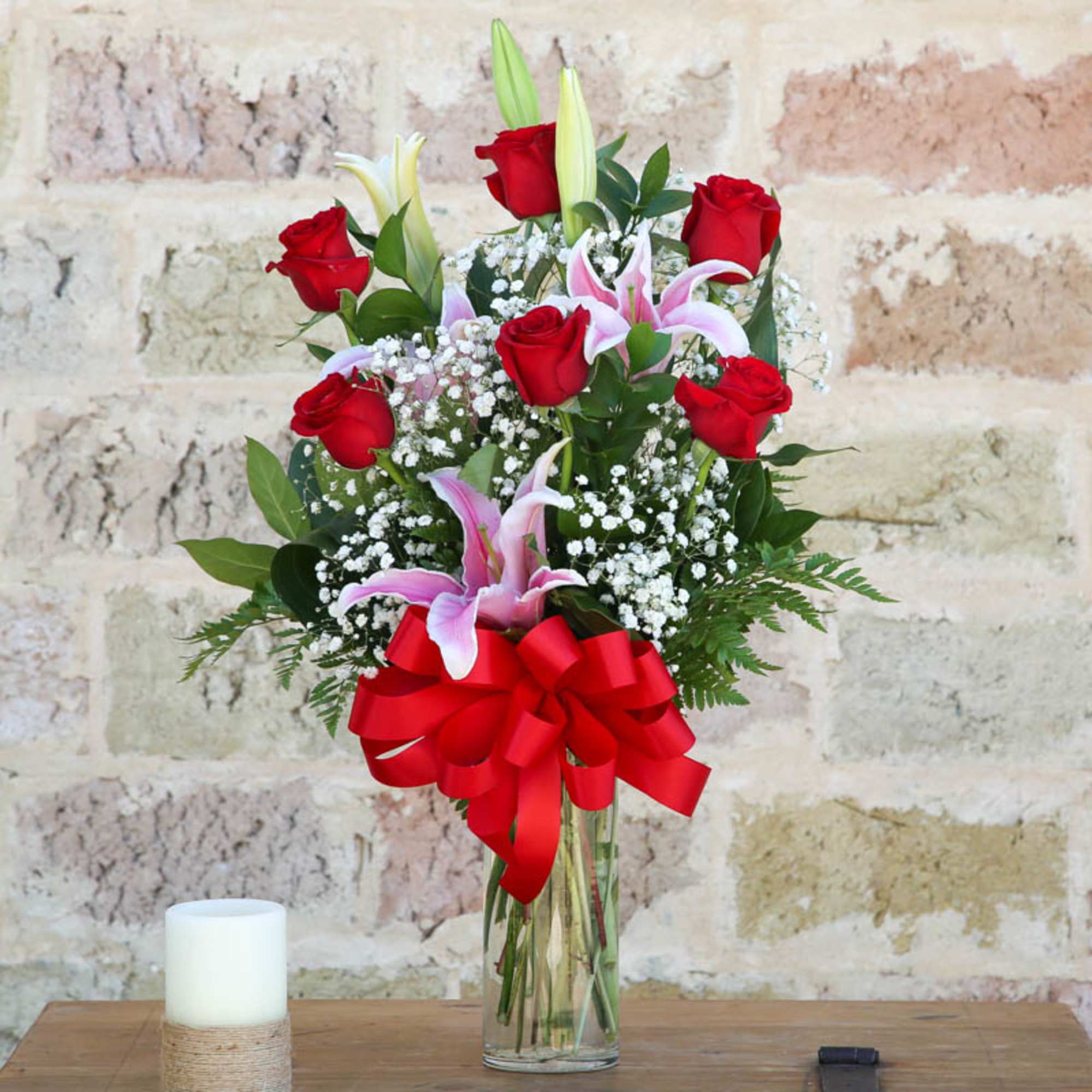 Bouquet of red roses and pink lilies in a clear glass vase with a red bow, photo 2 of 2