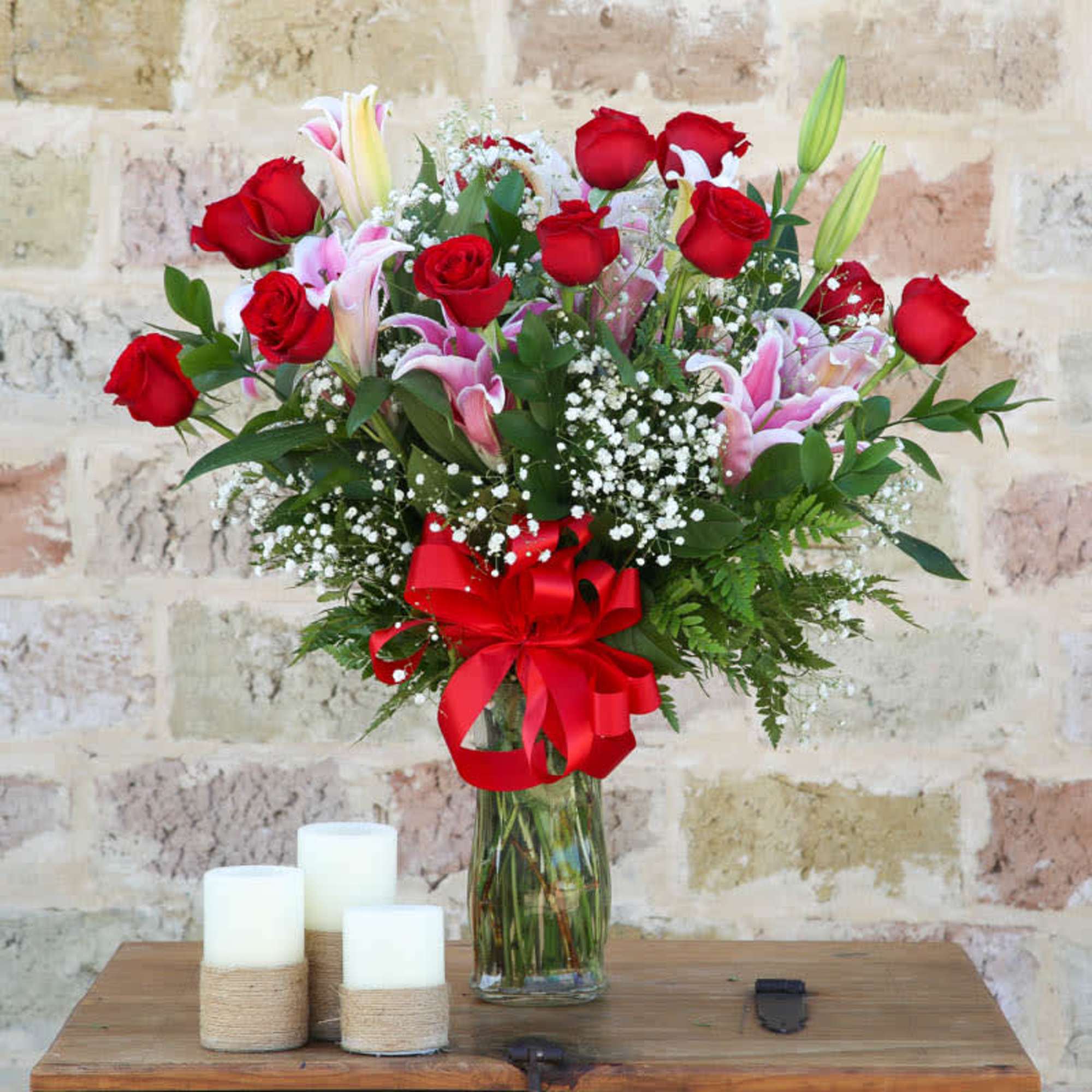 Bouquet of red roses and pink lilies in a glass vase with a red ribbon, photo 2 of 2