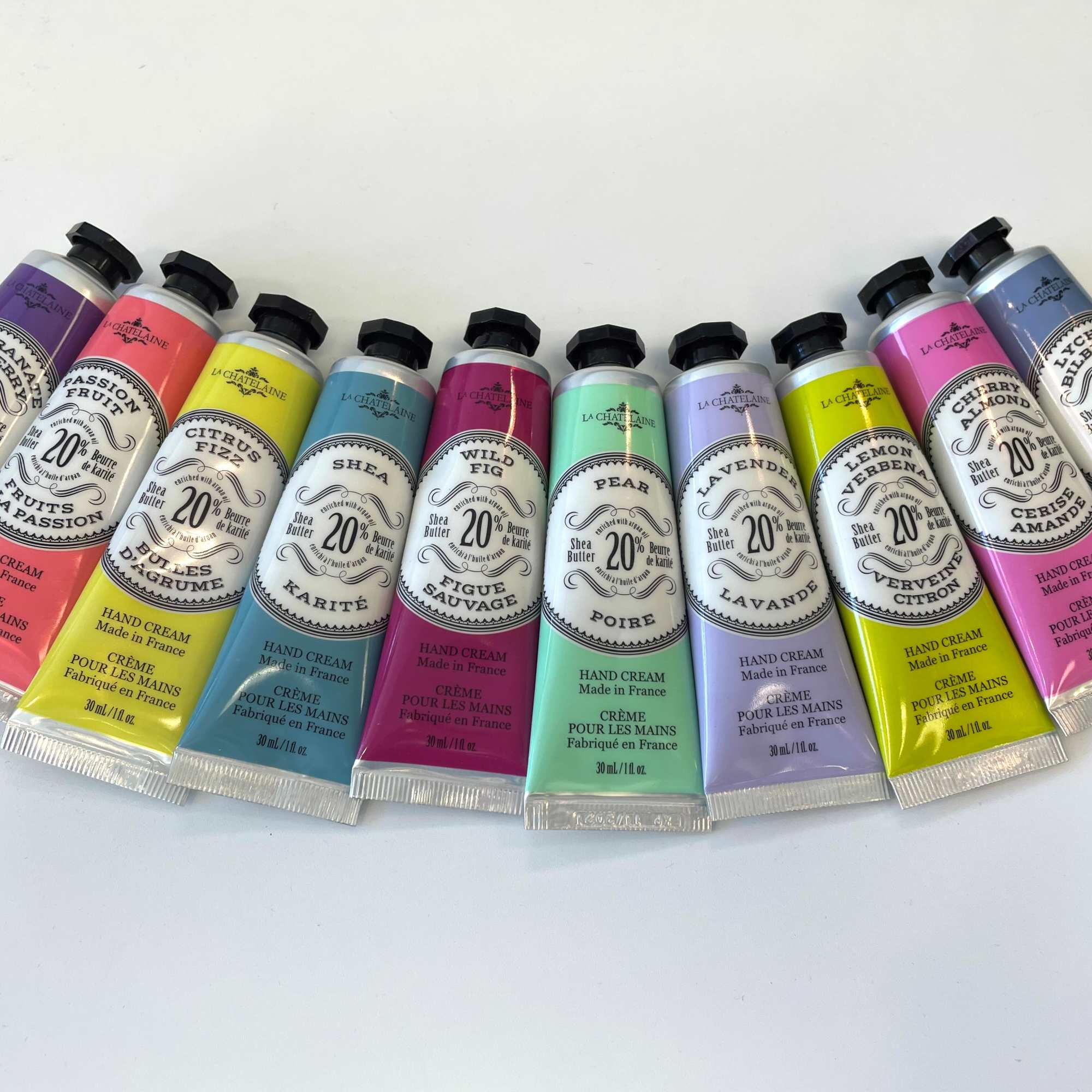 A row of colorful hand cream tubes arranged on a white surface