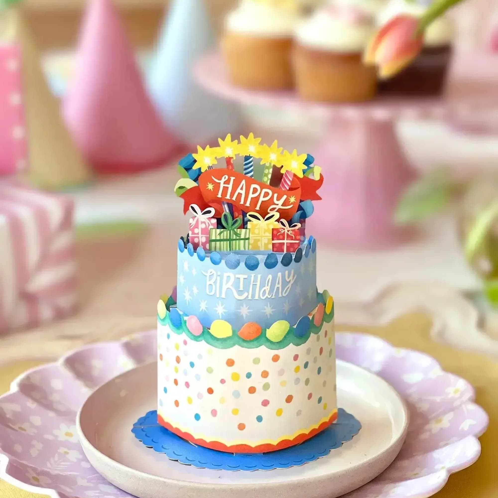 Tiered birthday cake with colorful decorations and a "Happy Birthday" topper
