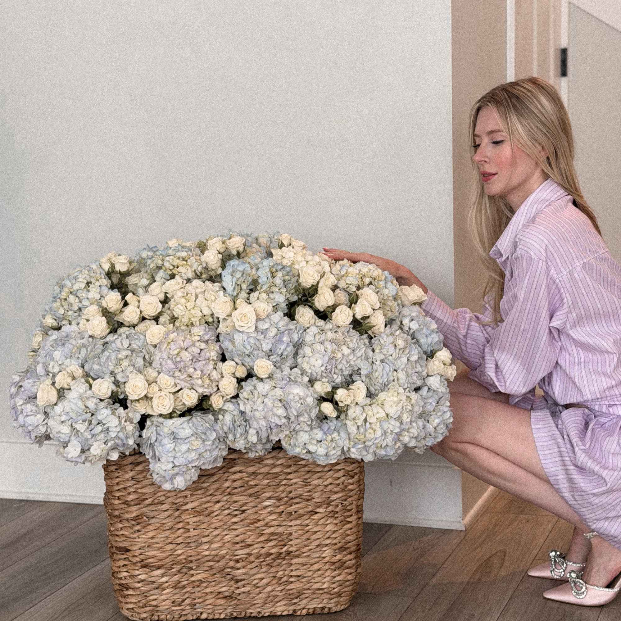 Large basket arrangement of pale blue hydrangeas and white roses