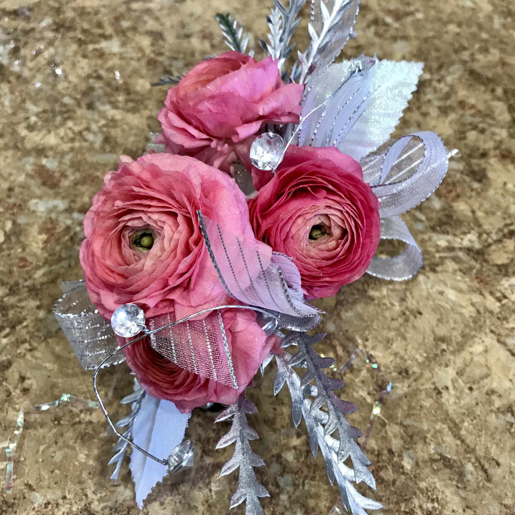 Pink ranunculus bouquet with silver ribbon and decorative accents