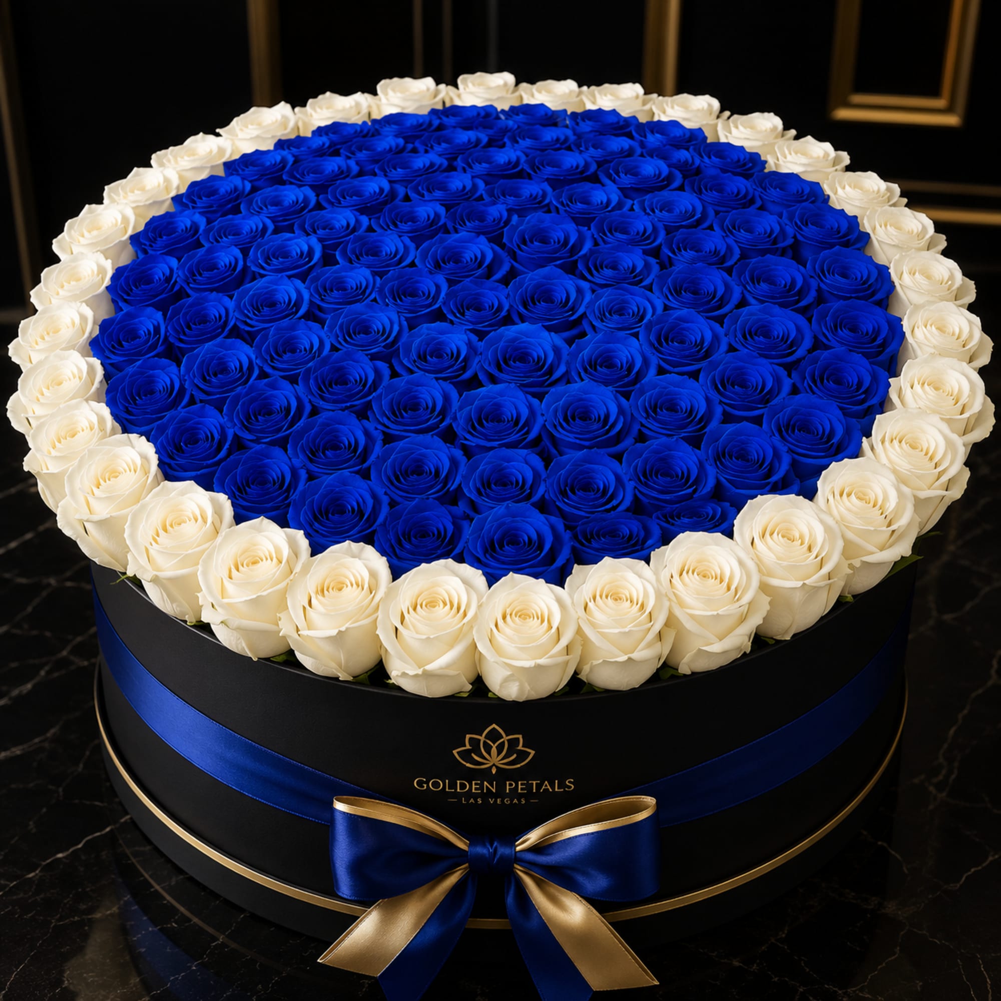 Round box of blue and white roses with a blue ribbon bow