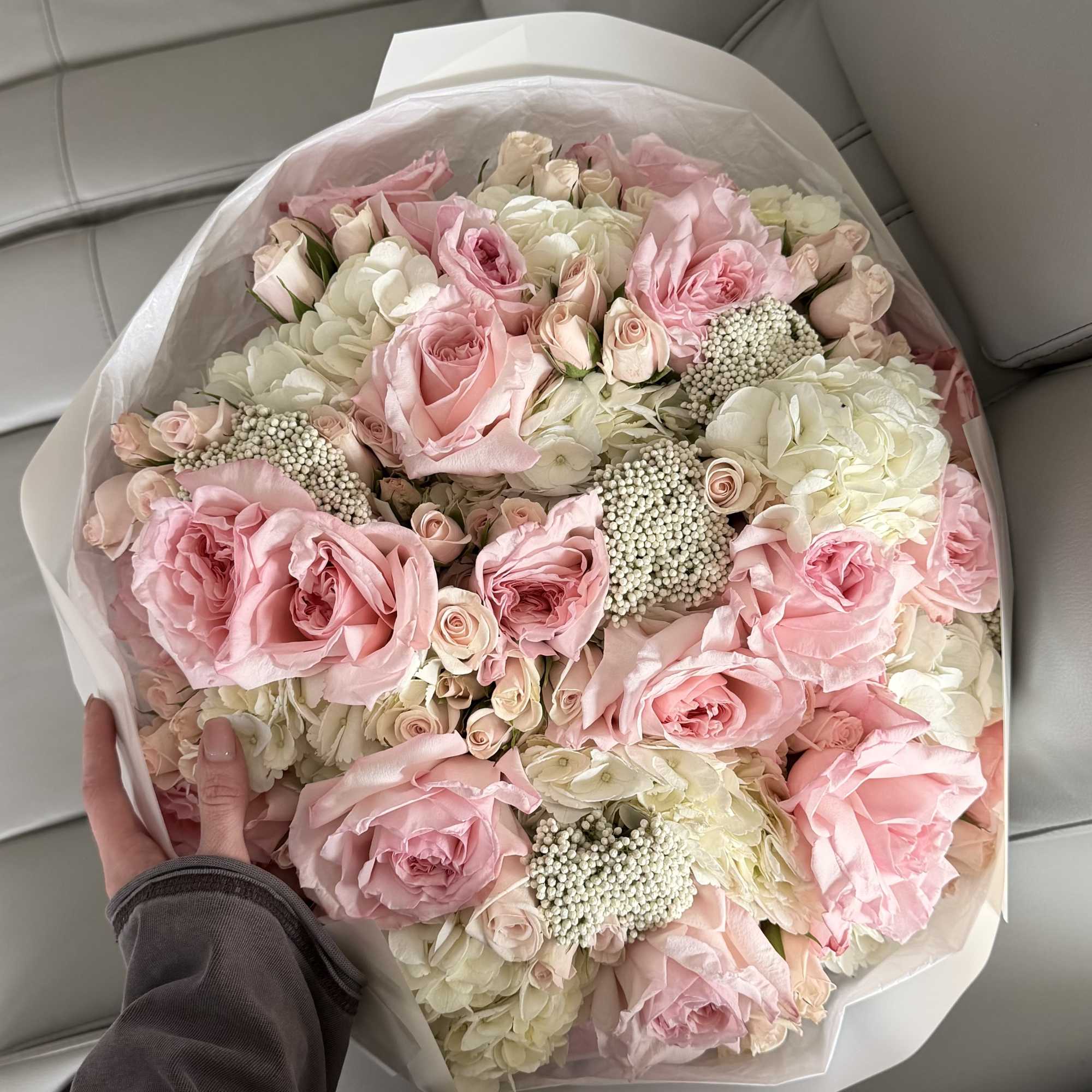 Large bouquet of pink and white roses wrapped in clear paper