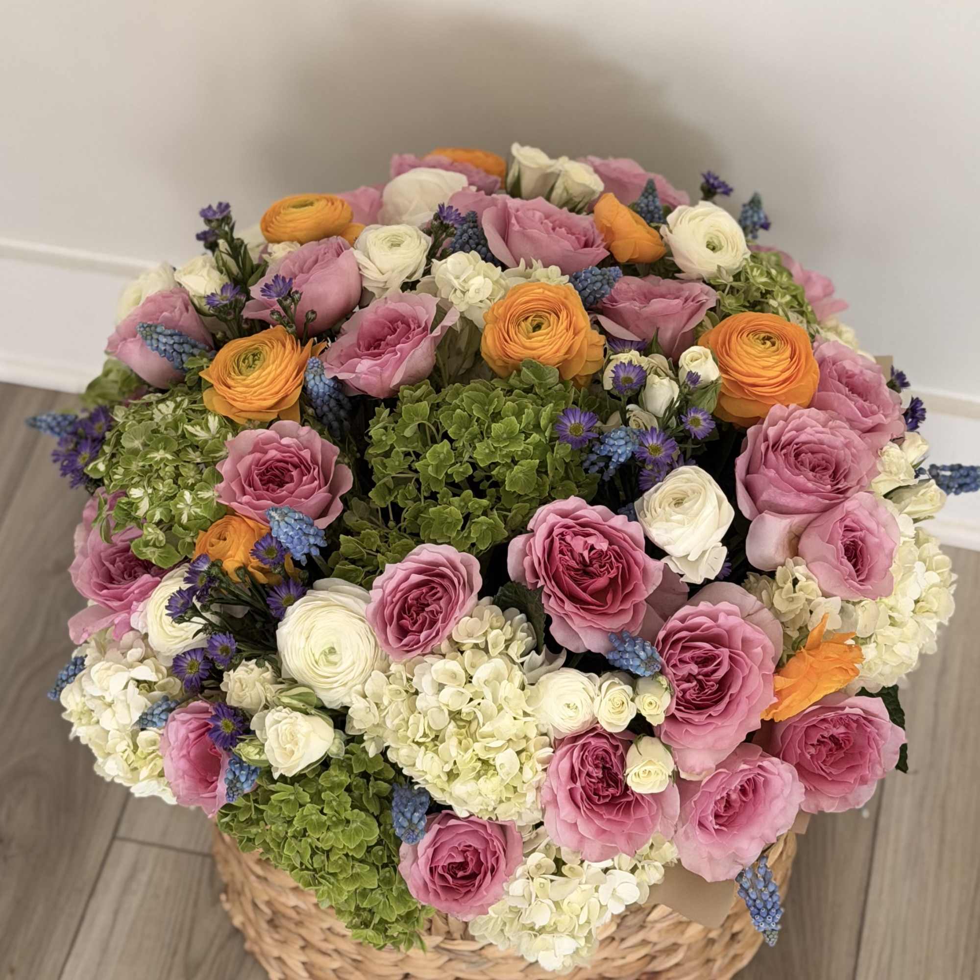 Large basket arrangement of pink, white, orange, and green flowers
