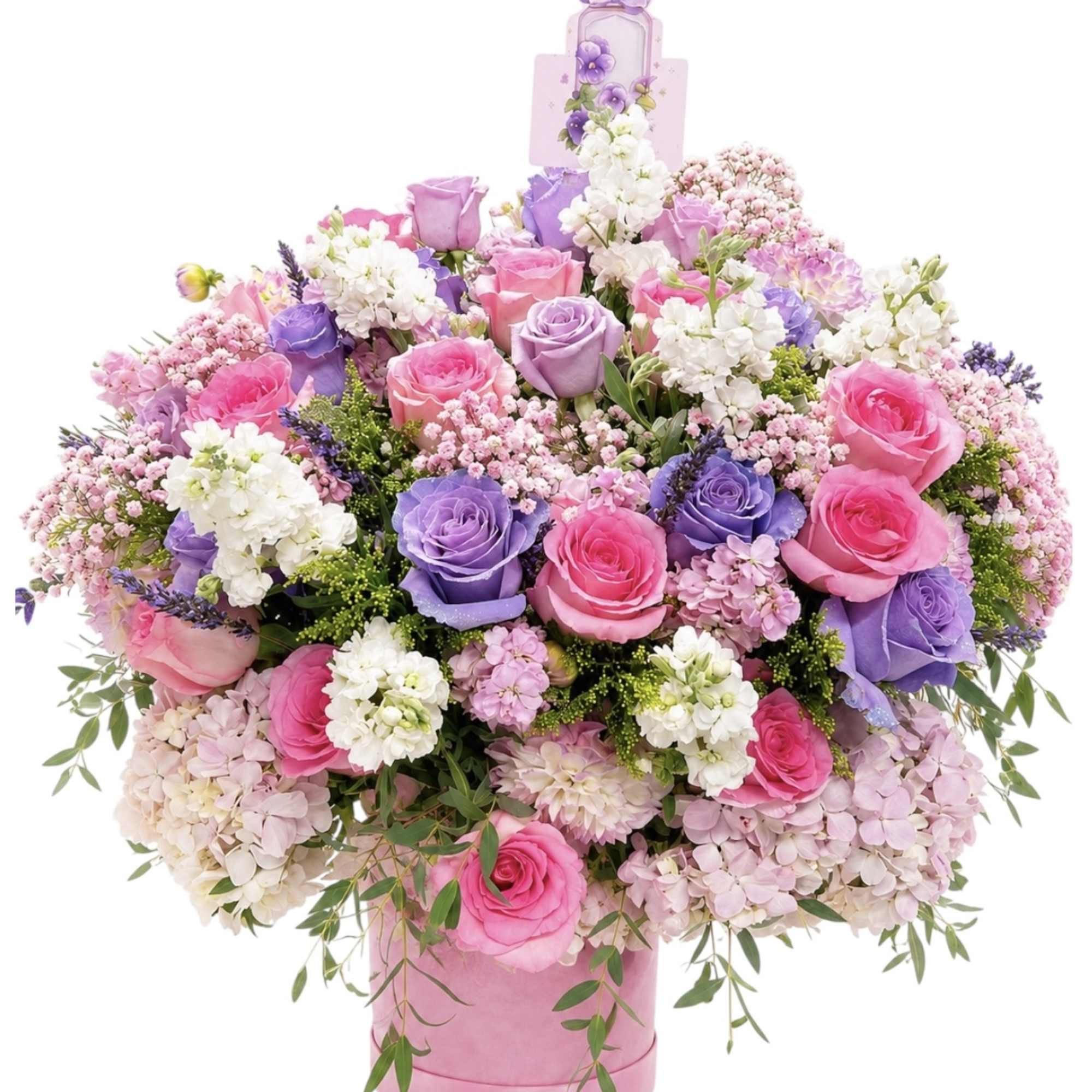 Pink and purple rose arrangement in a pink hatbox with a bow topper